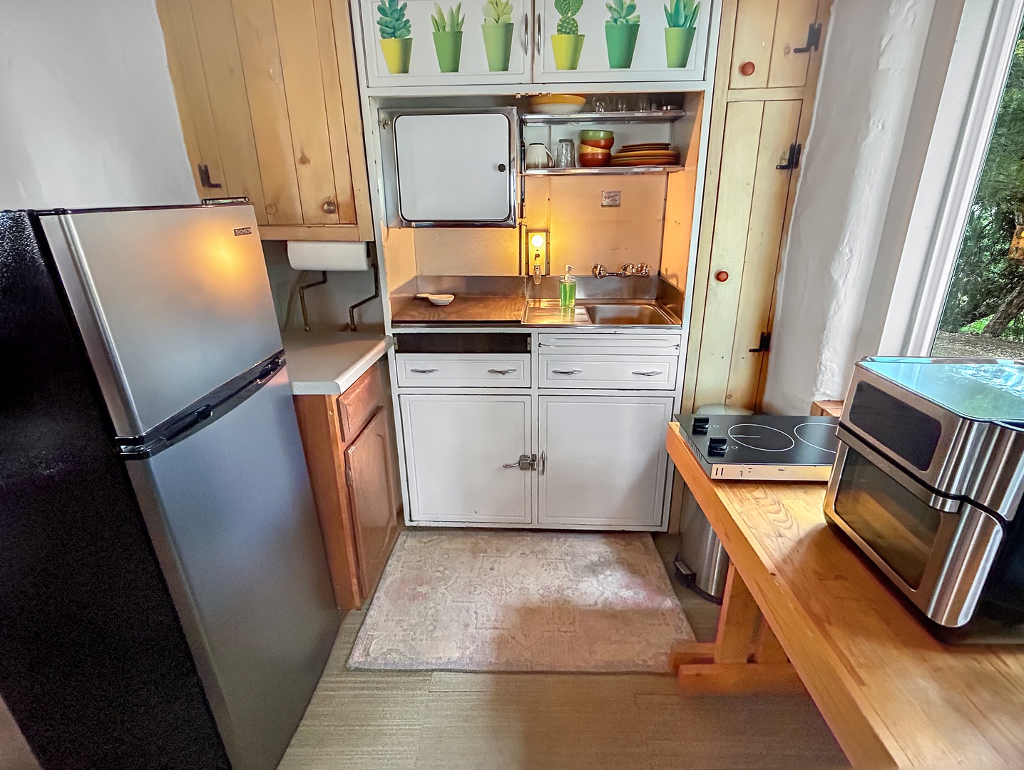 Your compact kitchen features everything you need: medium-size refrigerator, air fryer, and induction burner.