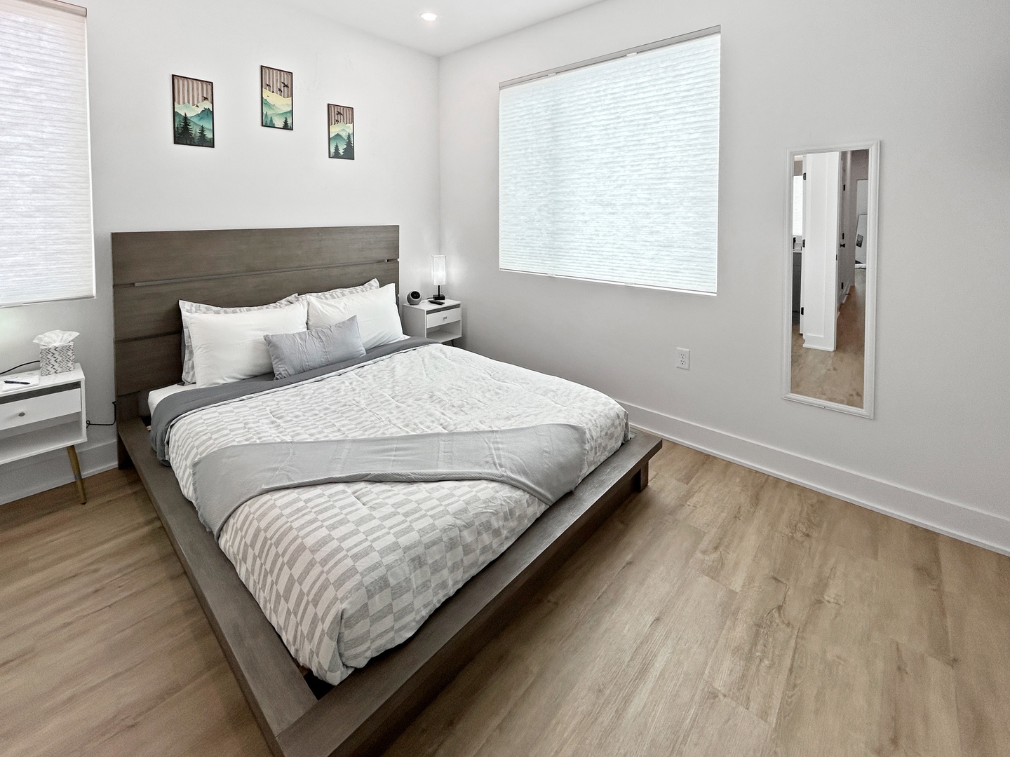 Sink into this cozy bedroom featuring a plush bed with soft linens, peaceful artwork, and plenty of natural light.