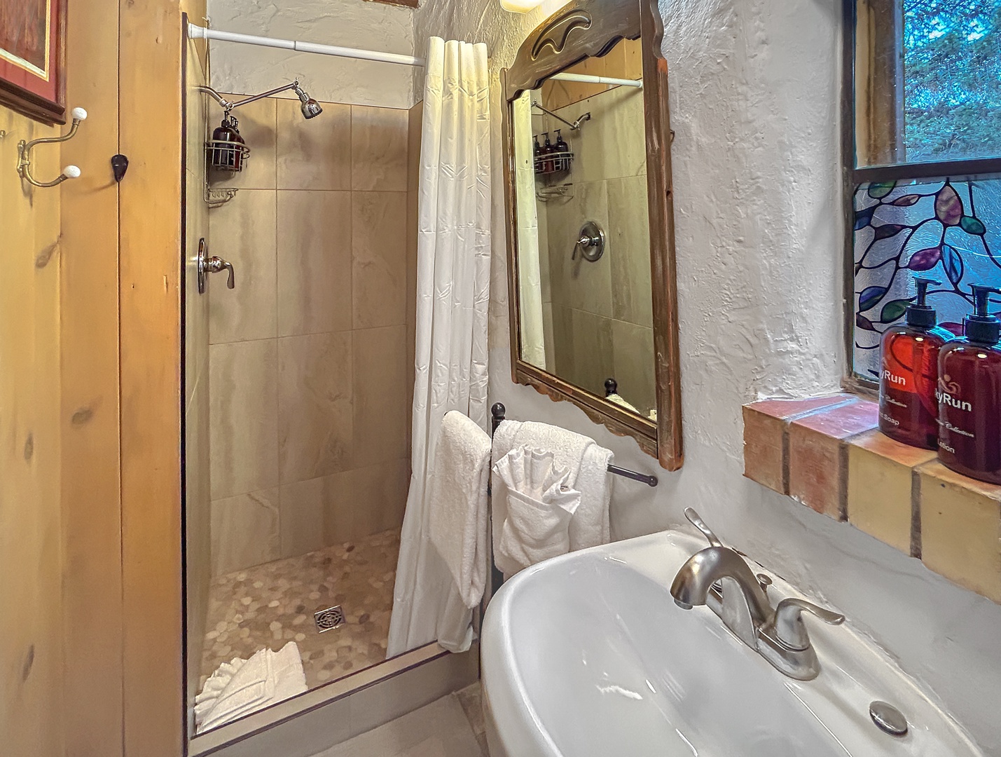 Step into your charming bathroom featuring a spacious walk-in shower, elegant fixtures, and thoughtful amenities to refresh after your adventures.