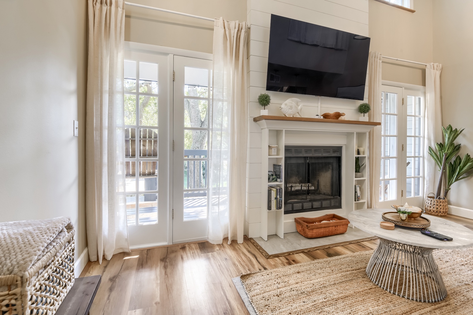 French doors open from the living room to the tree-shaded deck