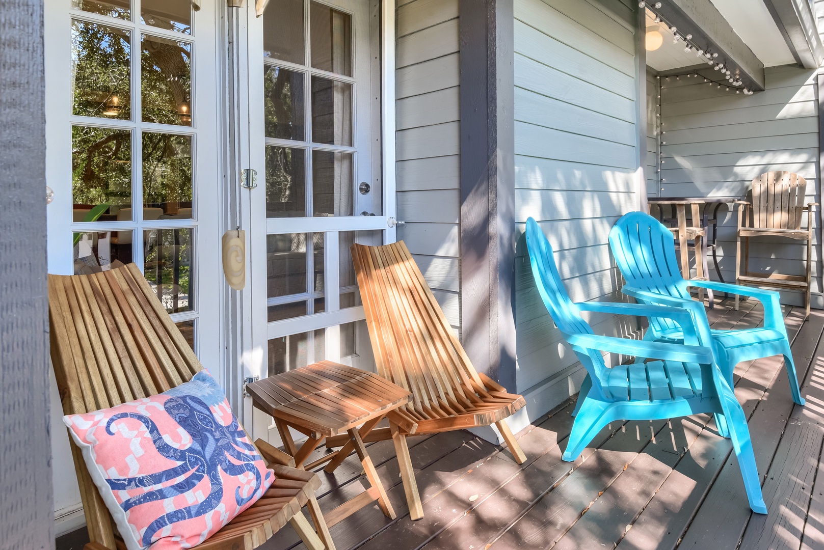 Mix of lounge and Adirondack chairs on the deck with string lights