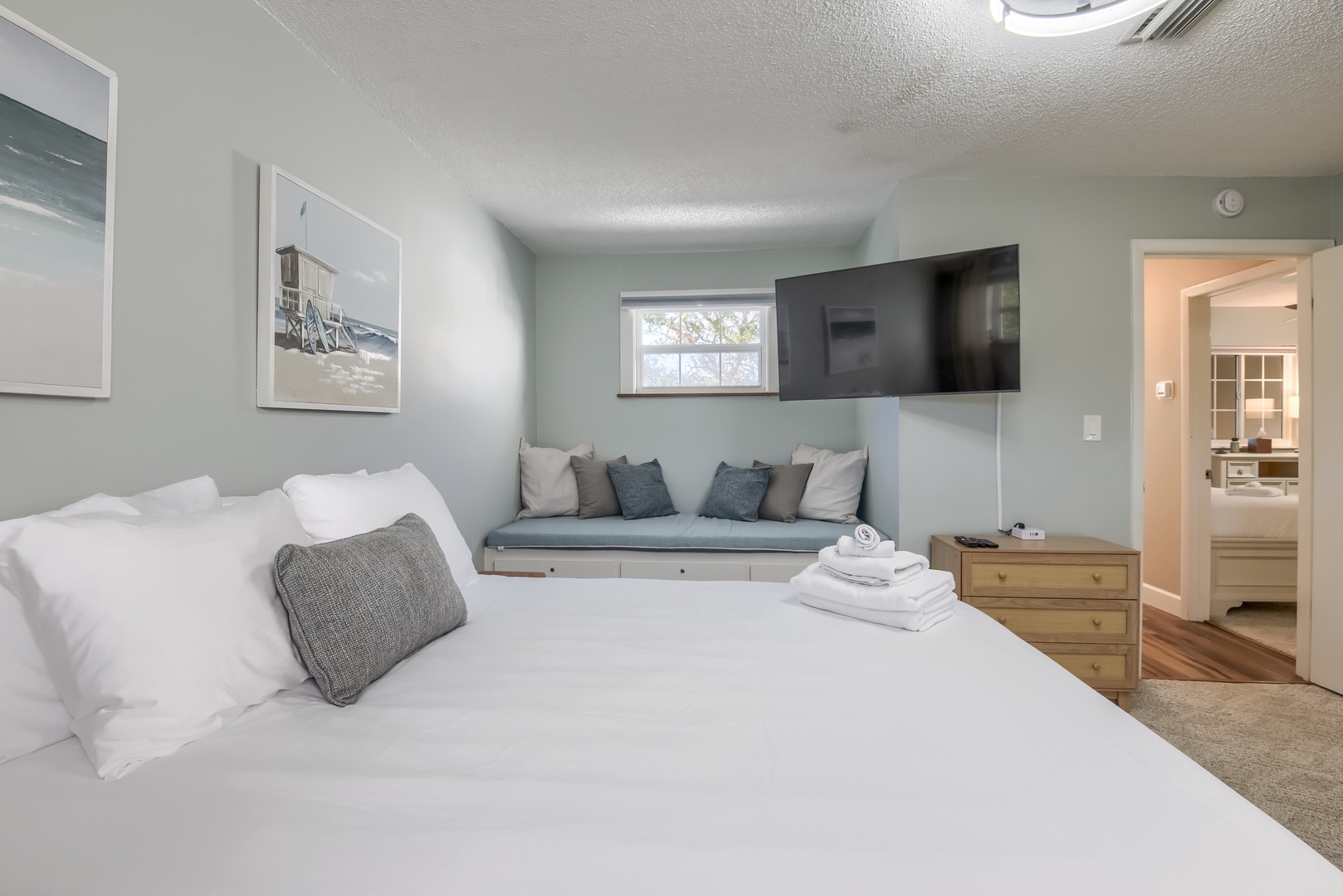 Unwind in bed with a wall-mounted TV and a cozy window seat