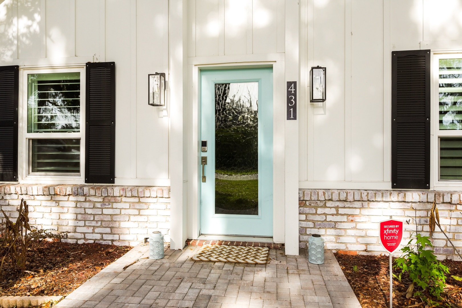 Charming entrance with white brick base.