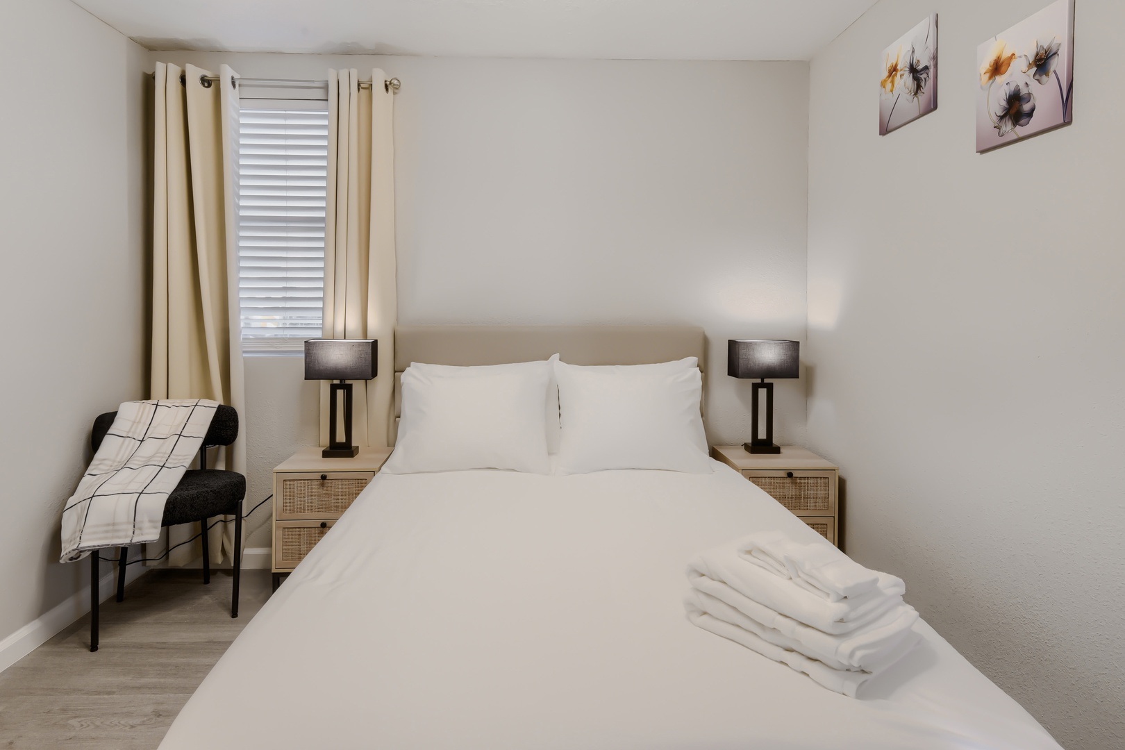 Second queen bedroom with crisp white linens and fresh towels