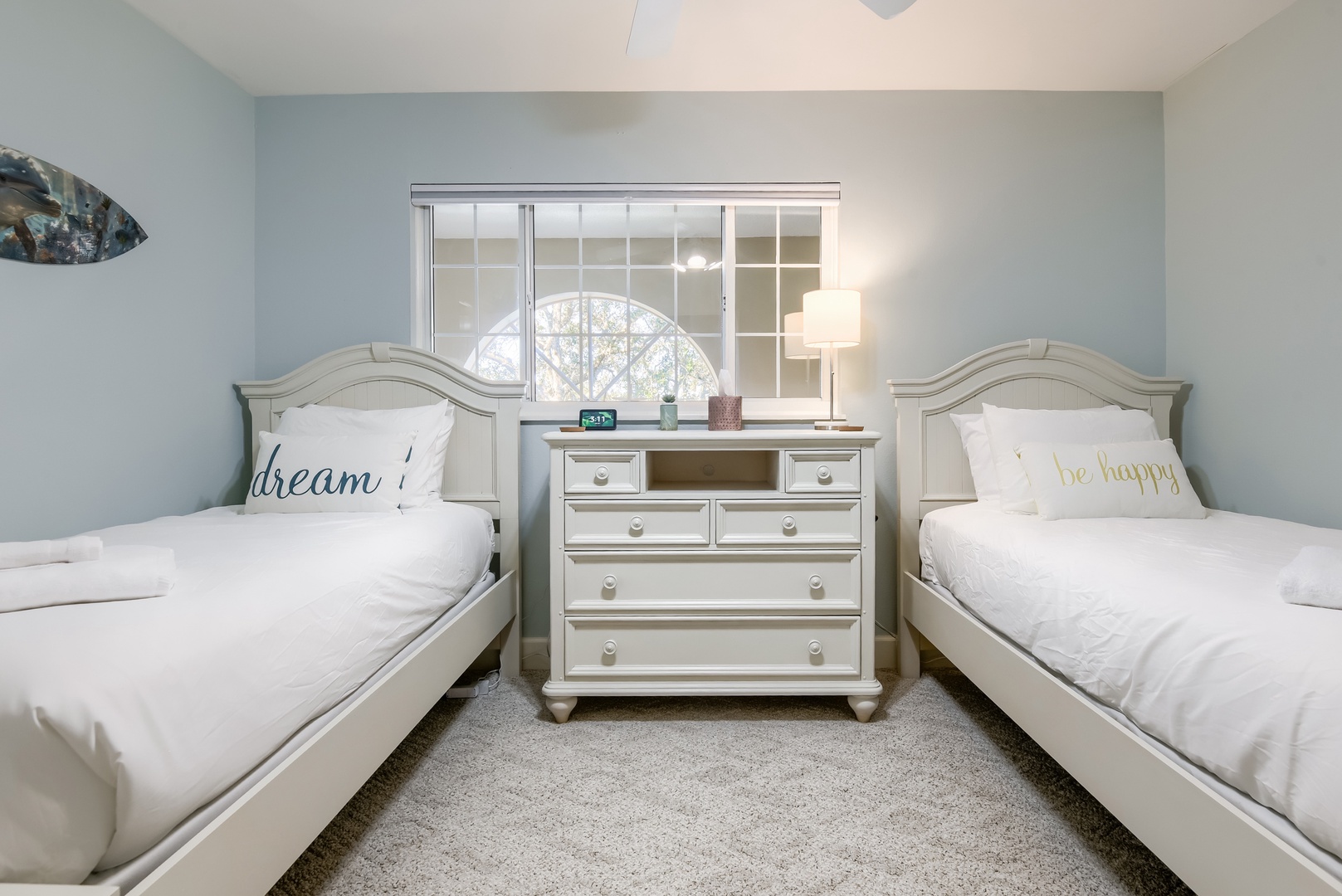 Twin beds with a shared dresser and bedside lamp
