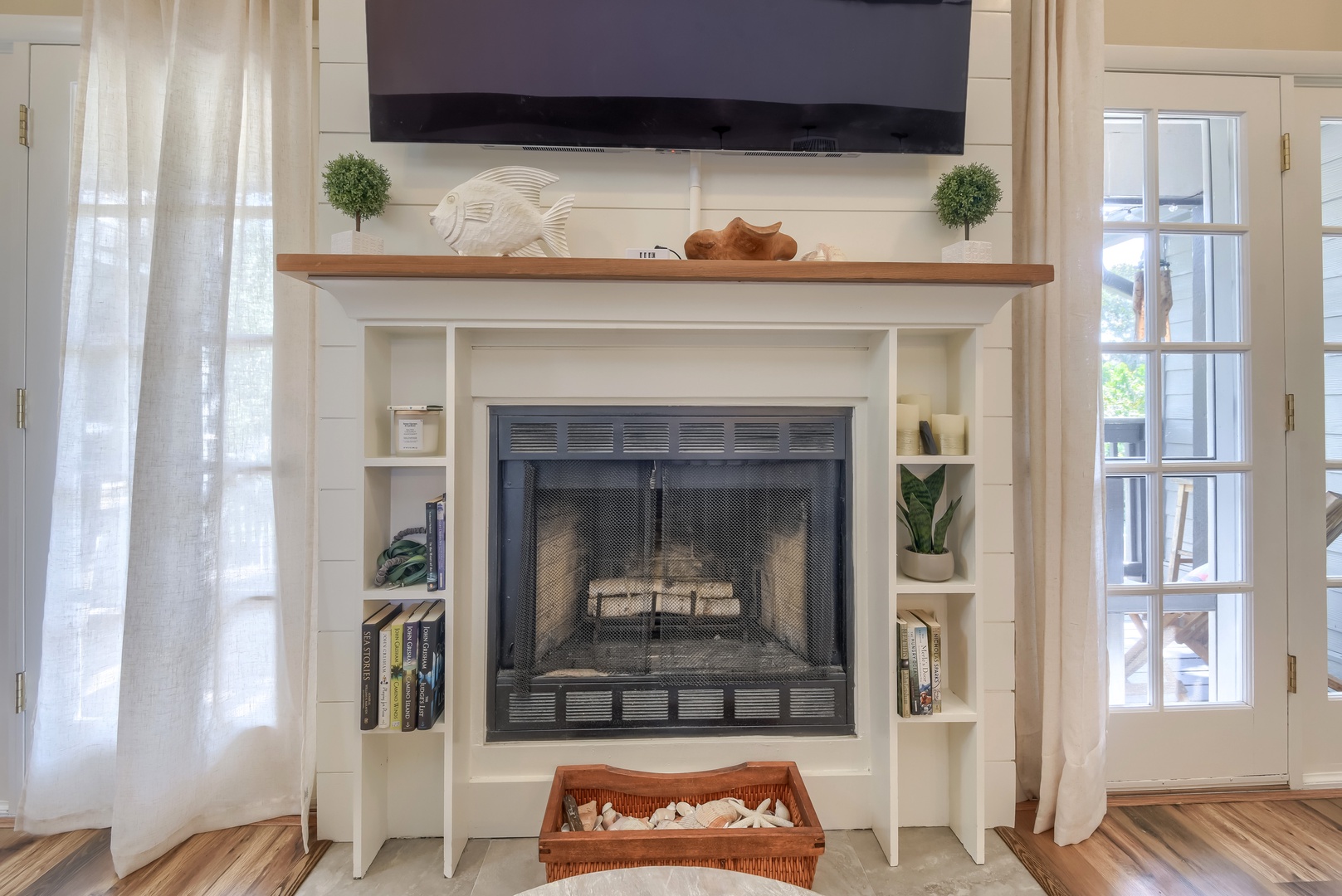Shiplap fireplace with built-in bookshelves and beachy accents