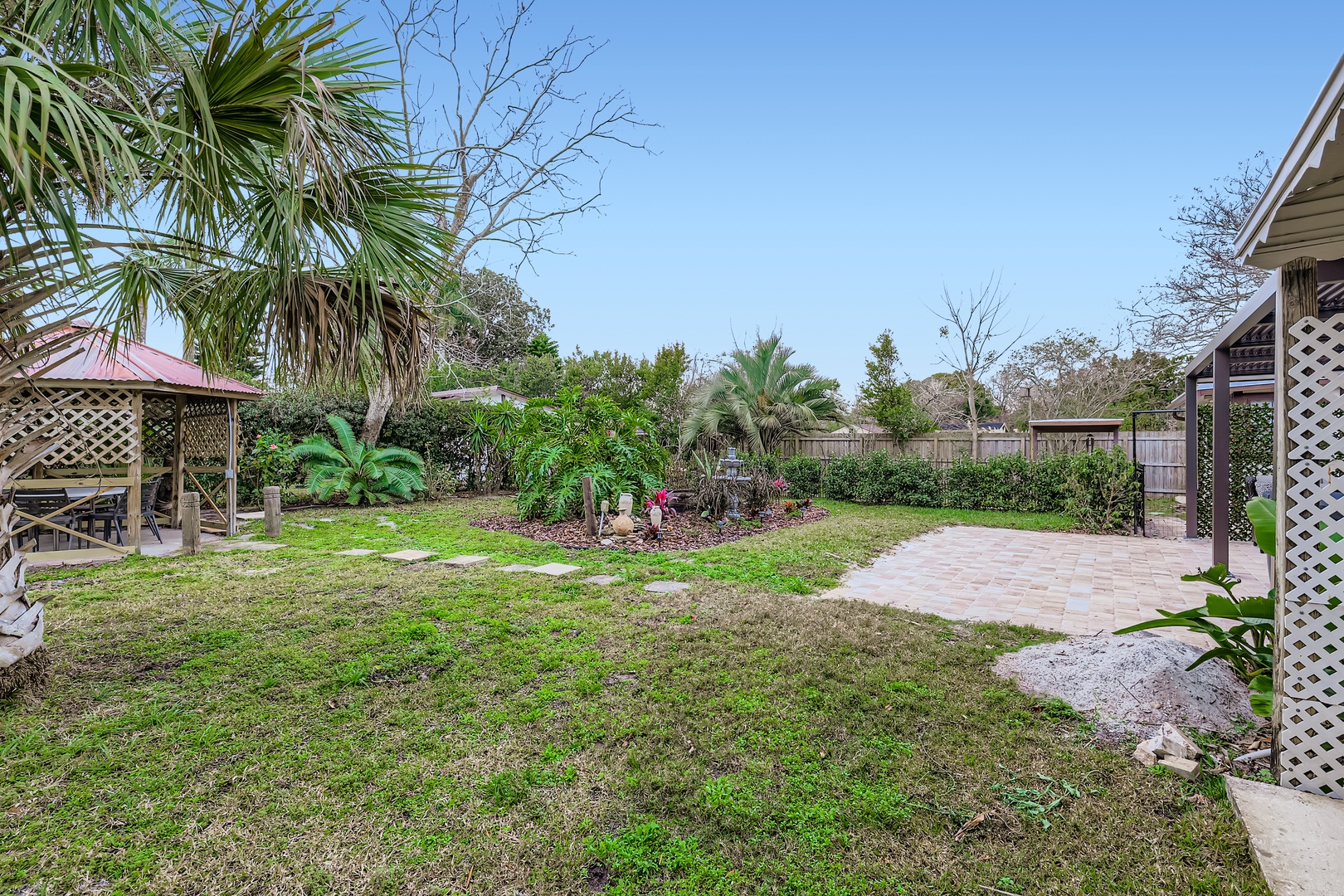 Spacious private backyard with tropical palms.