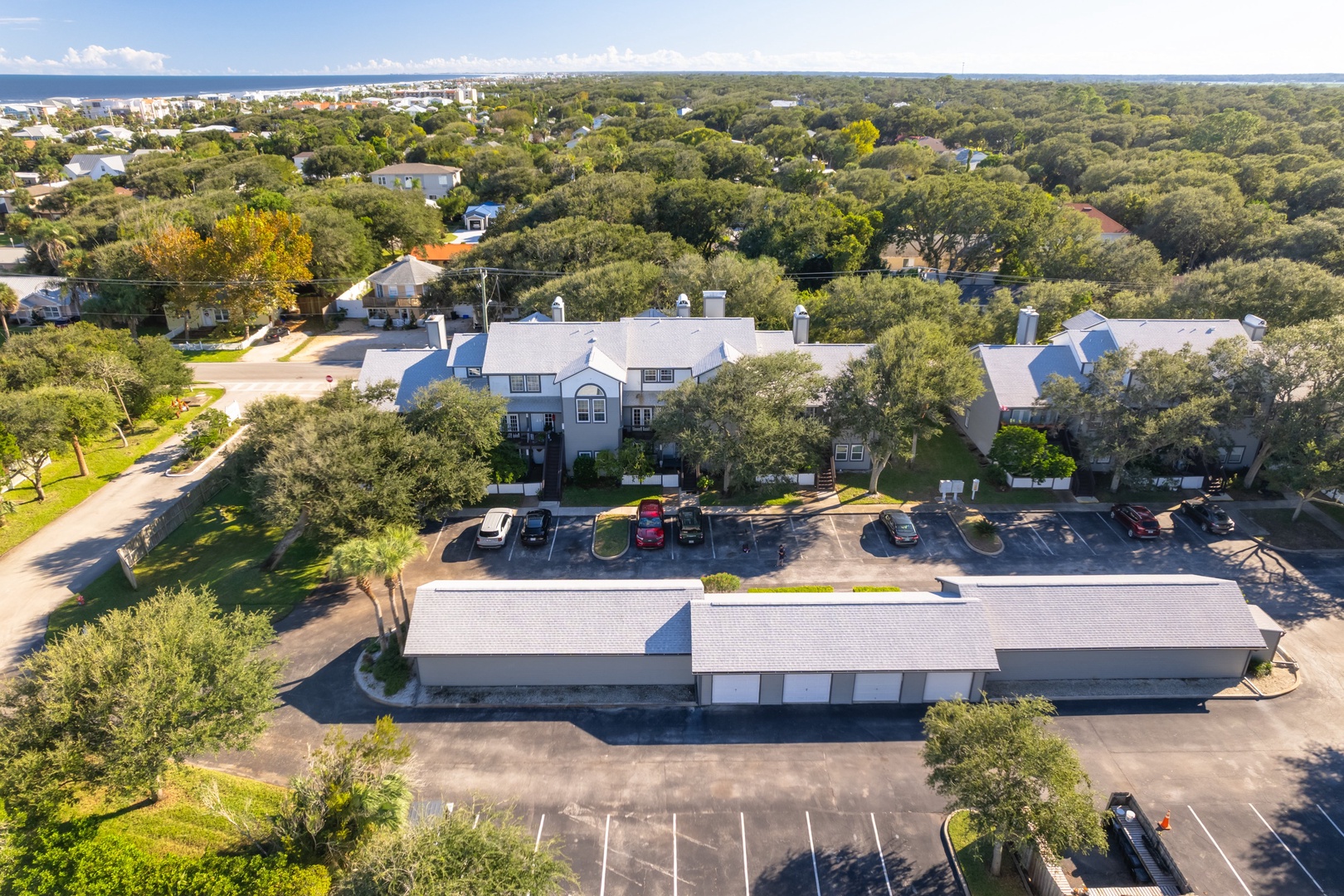 Aerial view of the complex with parking, nestled among the oaks