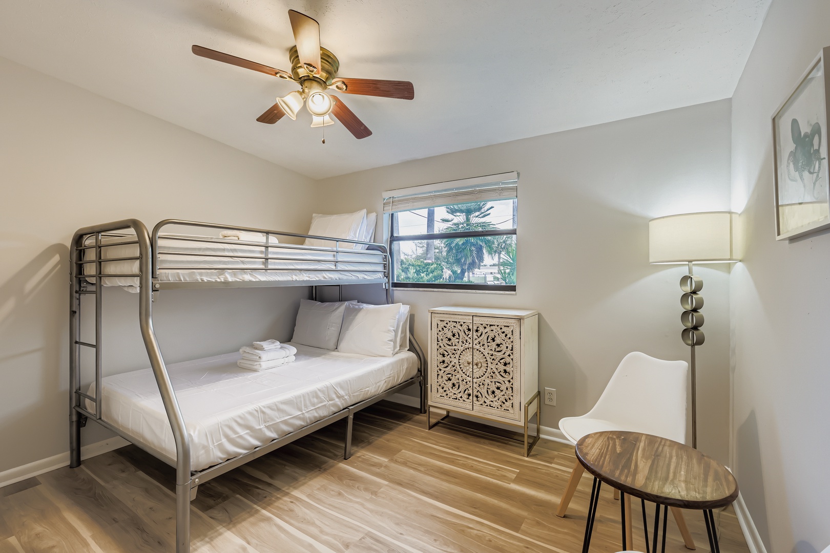 Your cozy bedroom features comfortable bunk beds with fresh linens, a ceiling fan for comfort, and natural light streaming through windows.