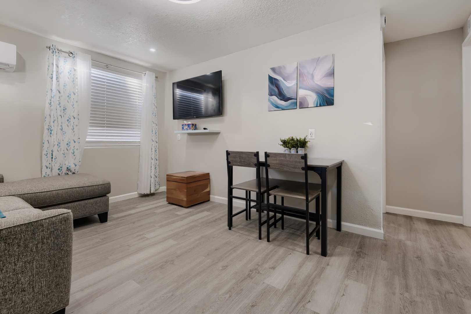 Living area with wall-mounted TV and dining table for two