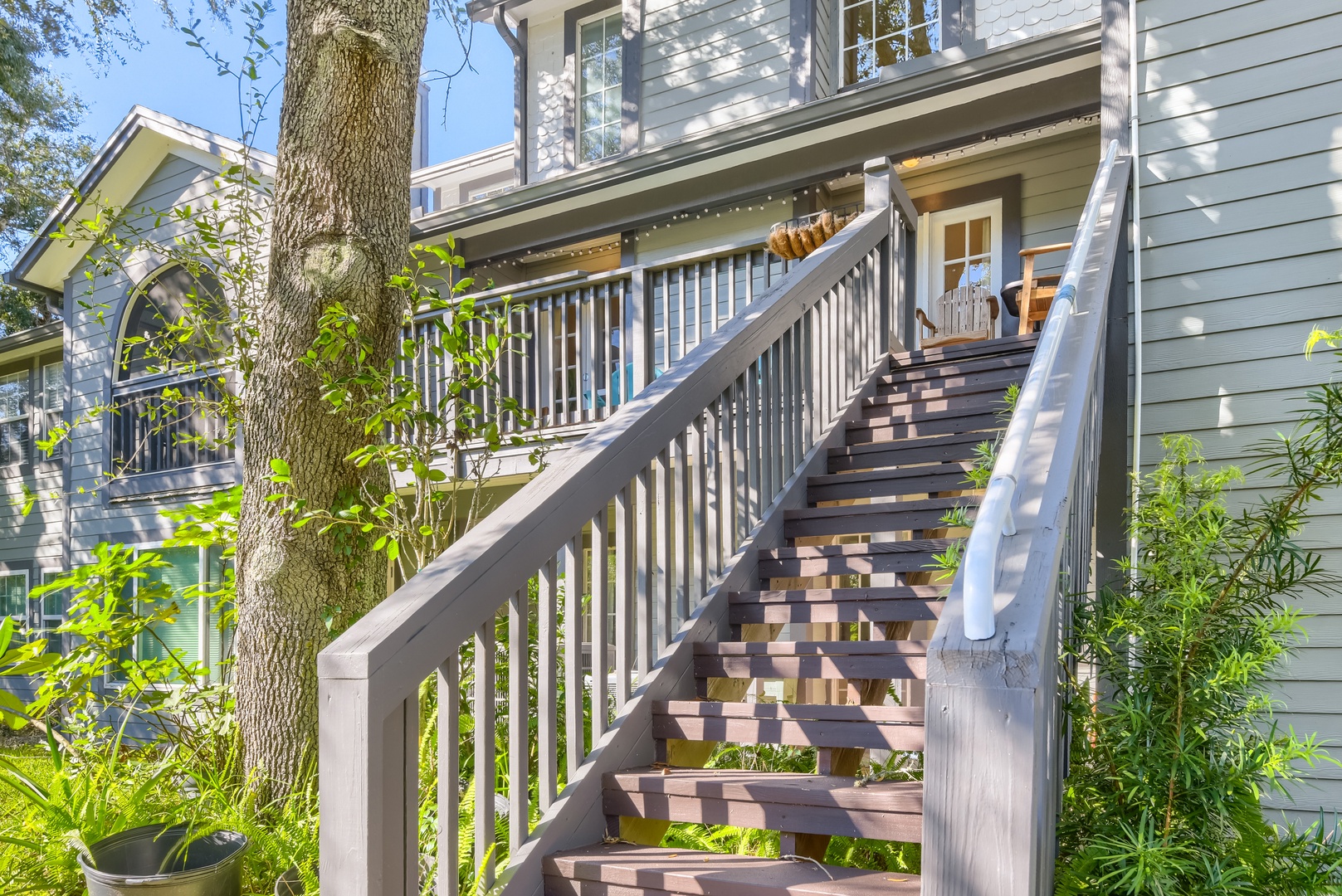 Stairway up to the deck, surrounded by greenery and oak shade