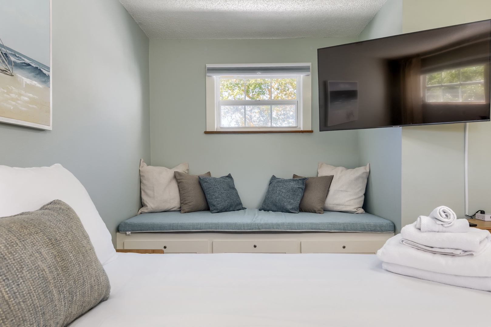 Cushioned window seat with storage drawers, a perfect spot to read