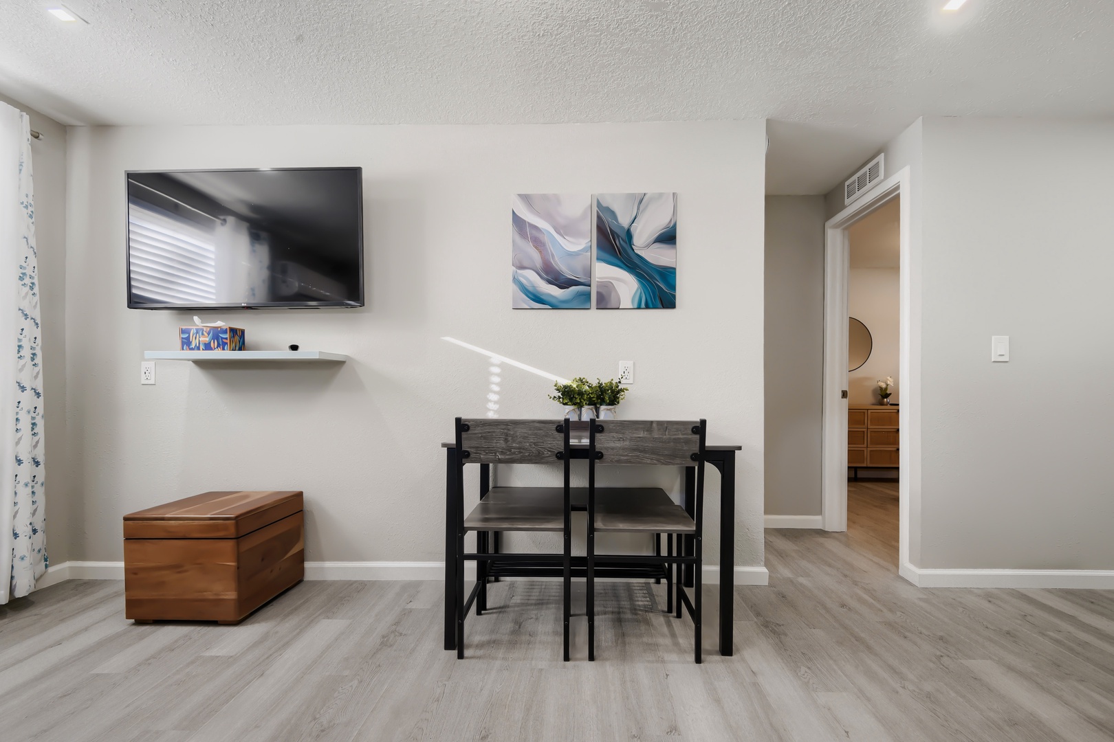 Dining nook for two next to the TV and hallway to bedrooms