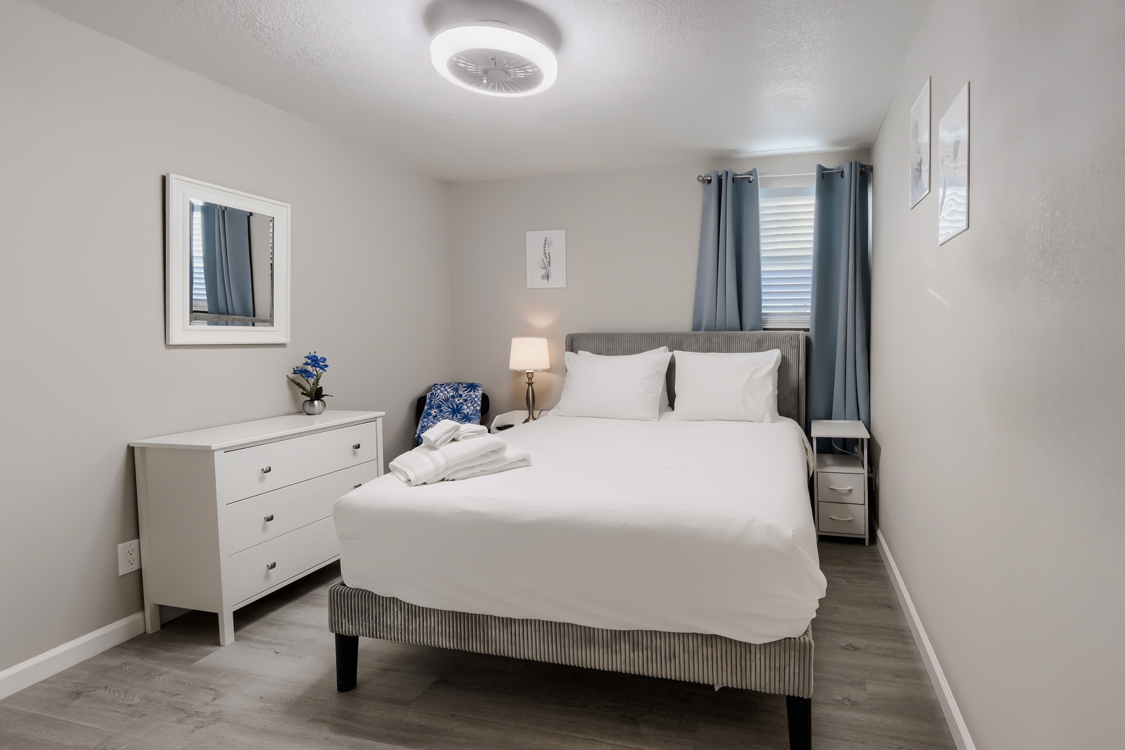 Primary bedroom queen bed with soft lighting and fresh white bedding