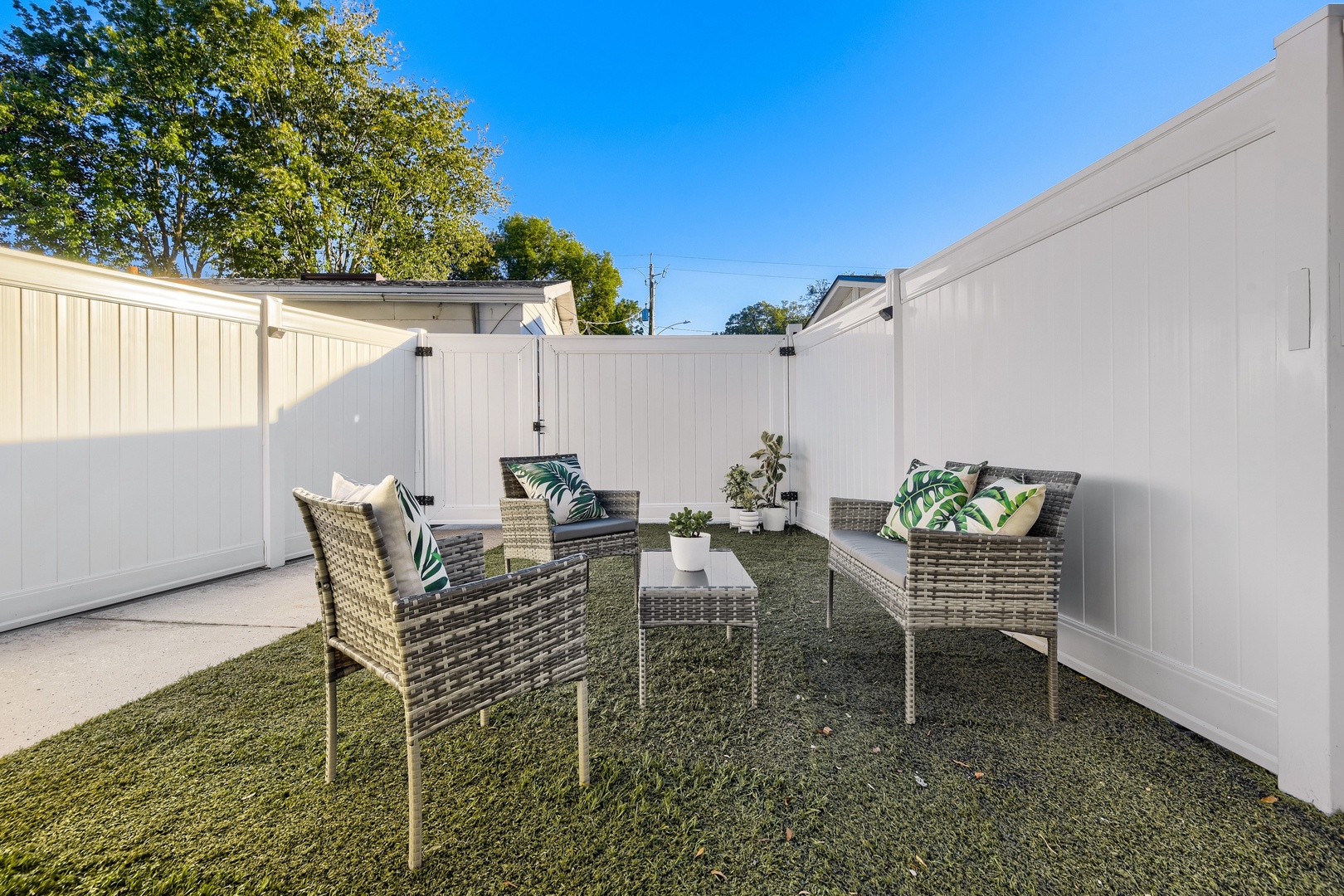 Fenced patio with turf lawn and outdoor seating for relaxing evenings