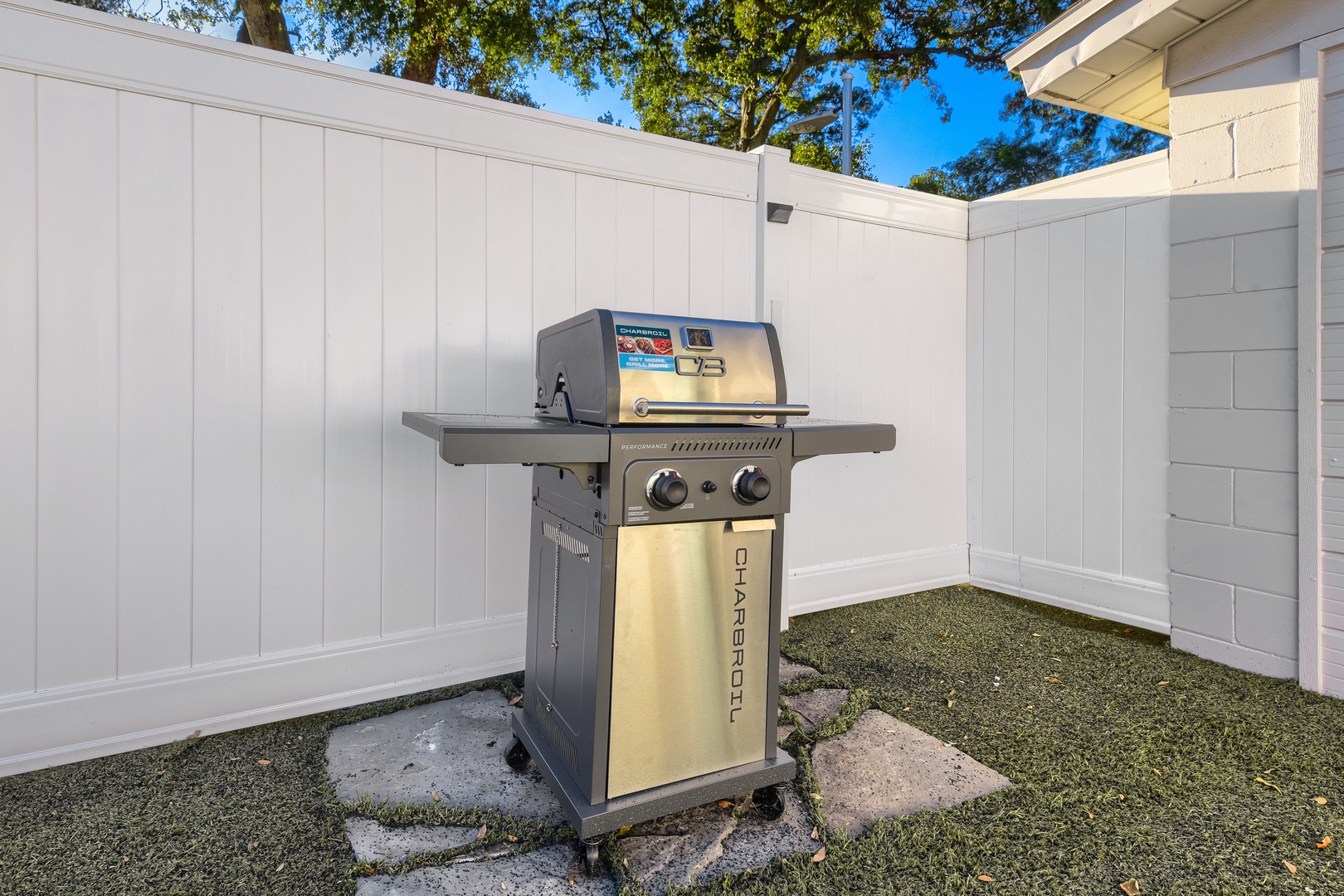 Gas grill on stone pavers in the private fenced yard