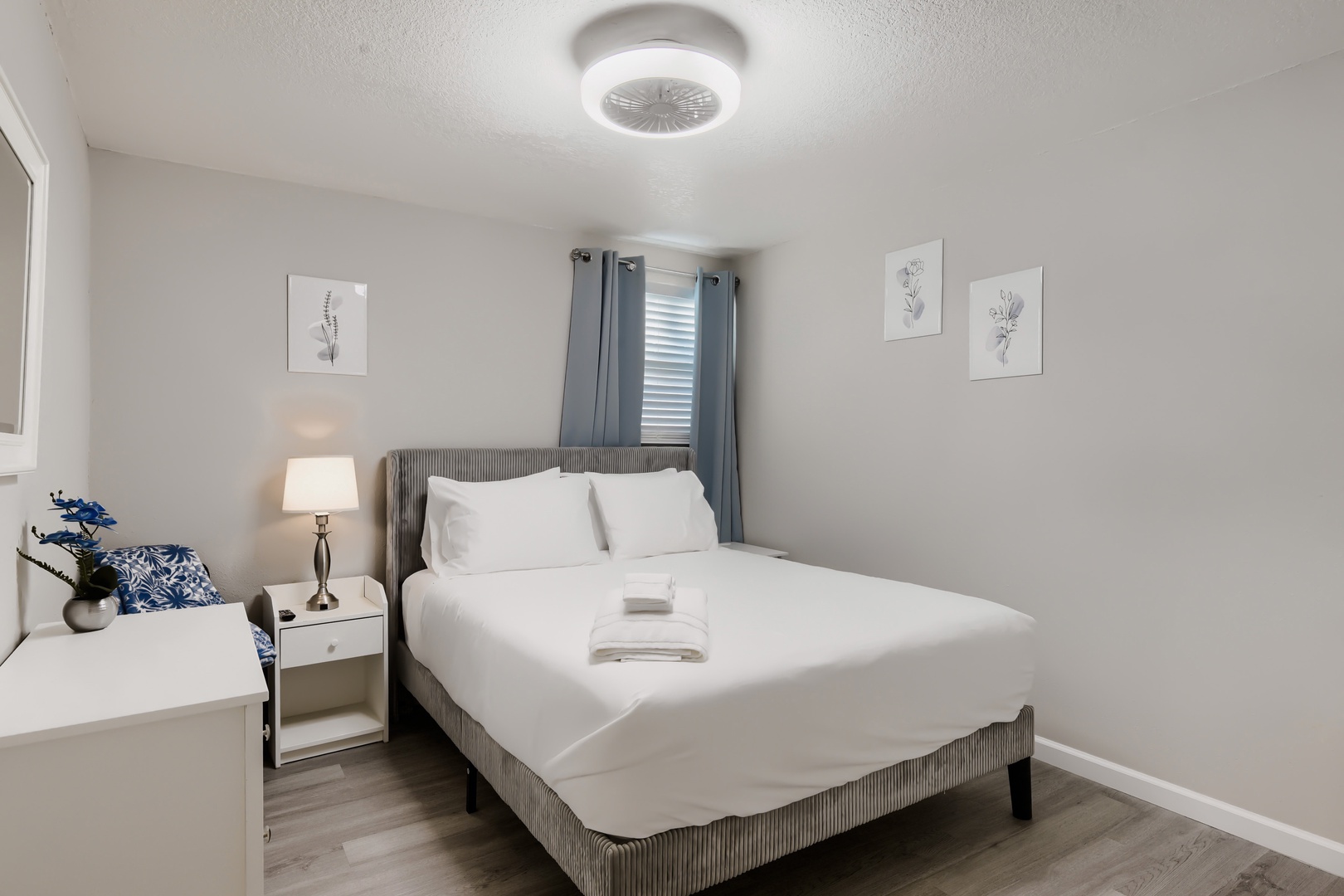 Primary bedroom with queen bed, fresh linens, and ceiling fan light