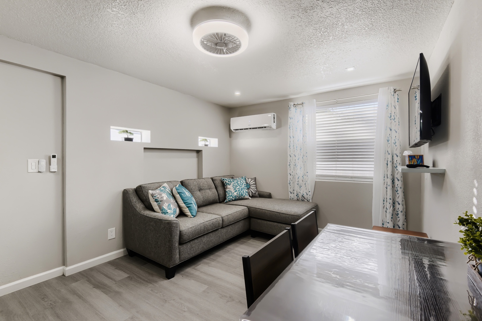 Bright living room with queen sleeper sectional, smart TV, and mini-split A/C
