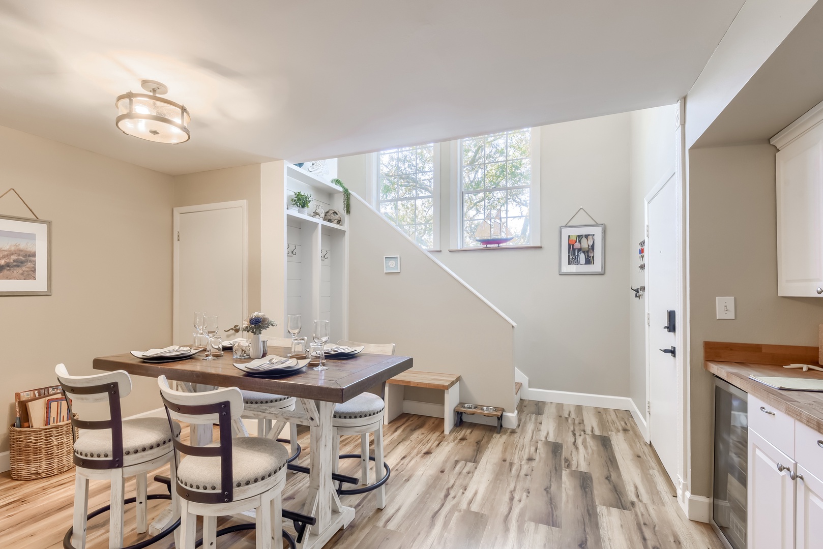 Farmhouse dining table with cushioned seating and a handy wine fridge nearby