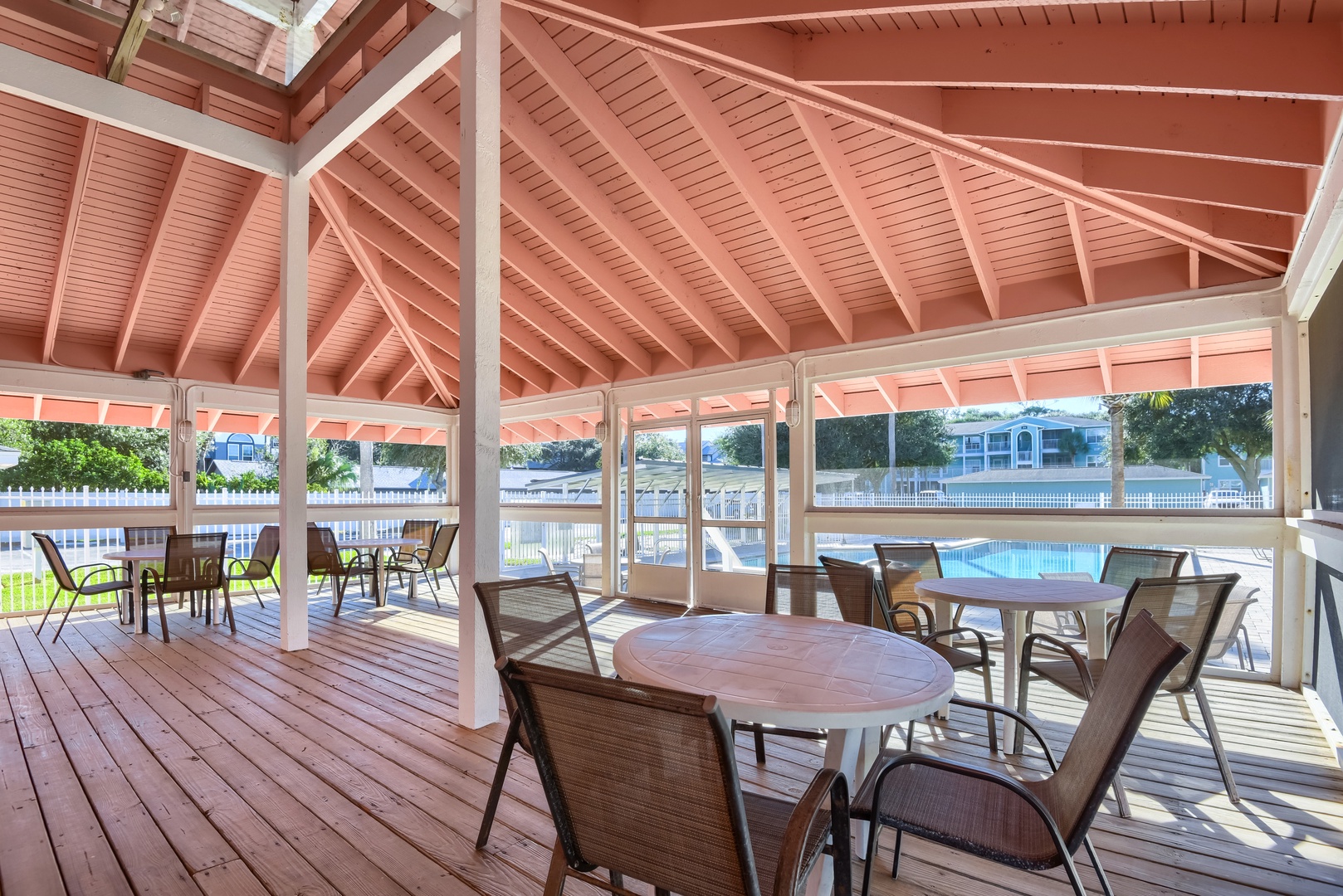 Screened pavilion with tables overlooking the pool, great for shady lunches