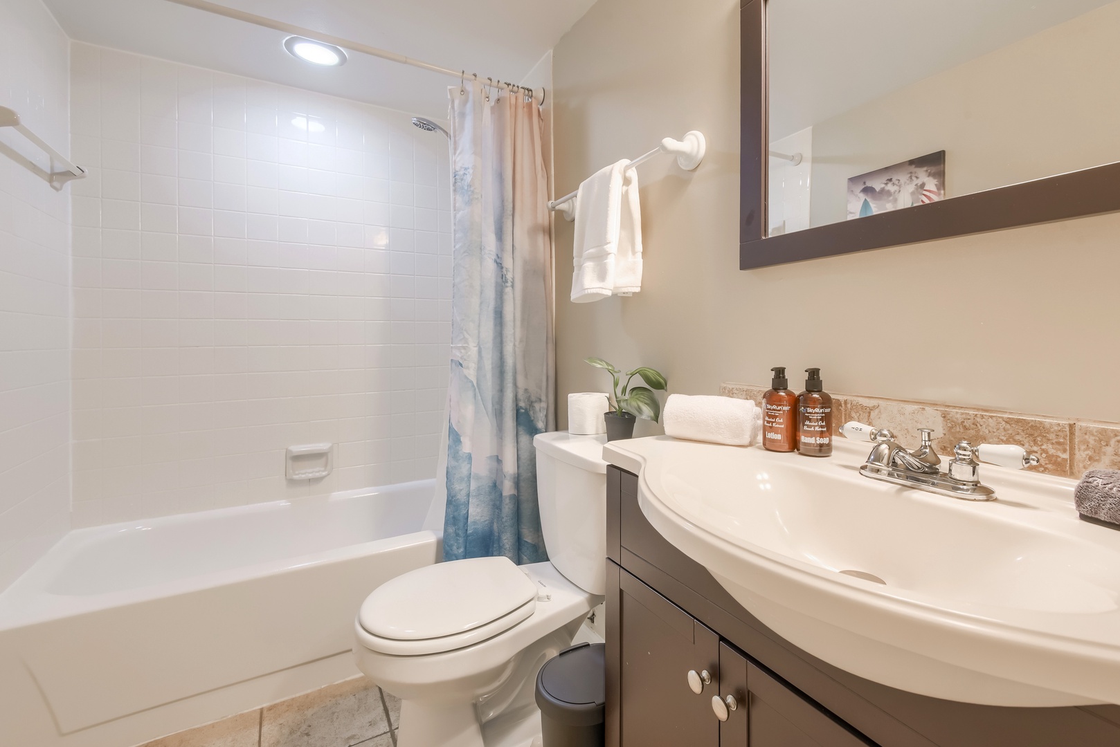 Full bathroom with tub and shower combo and fresh towels