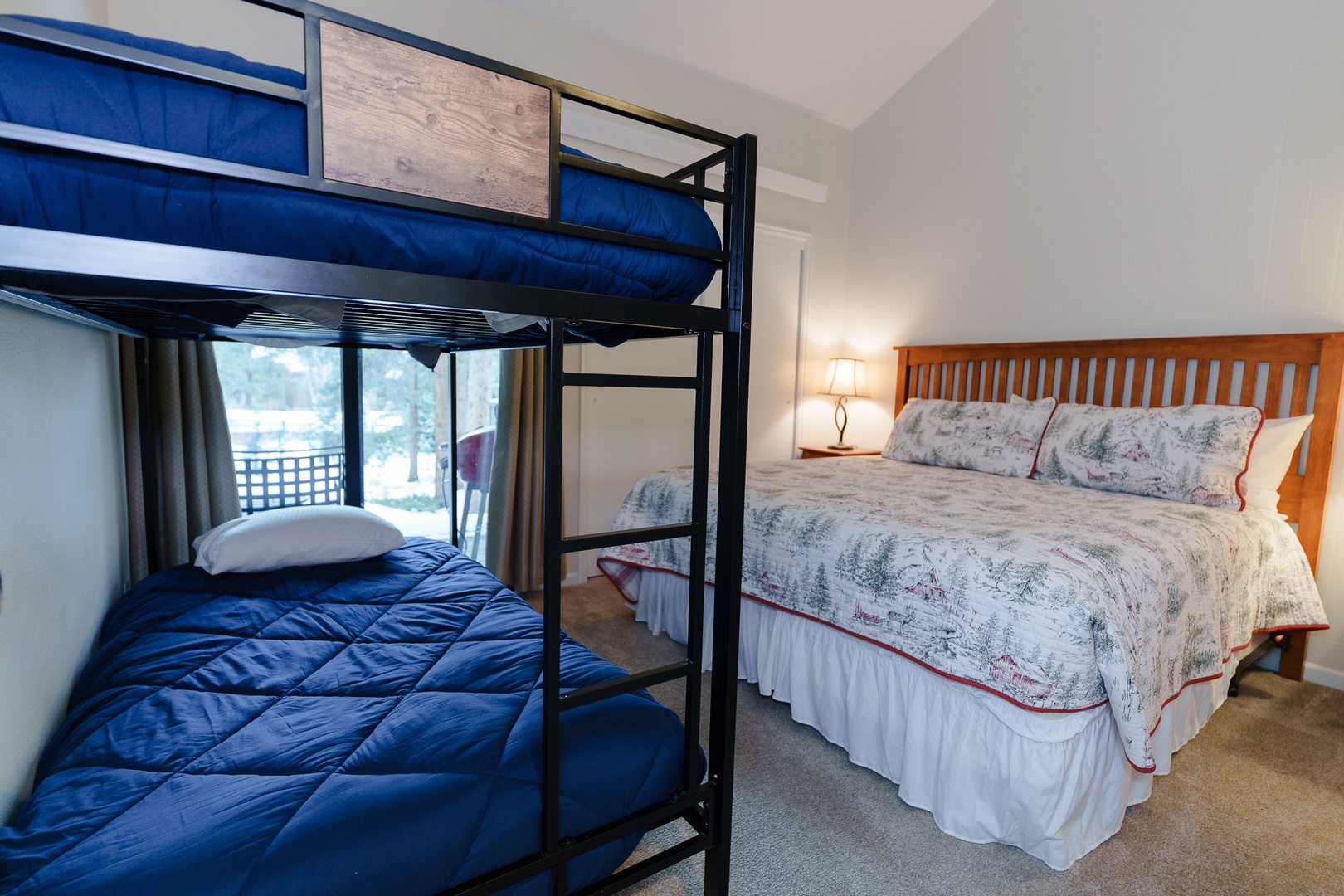 Comfortable bedroom with both a queen bed and bunk beds - perfect for families or groups sharing your stay together.