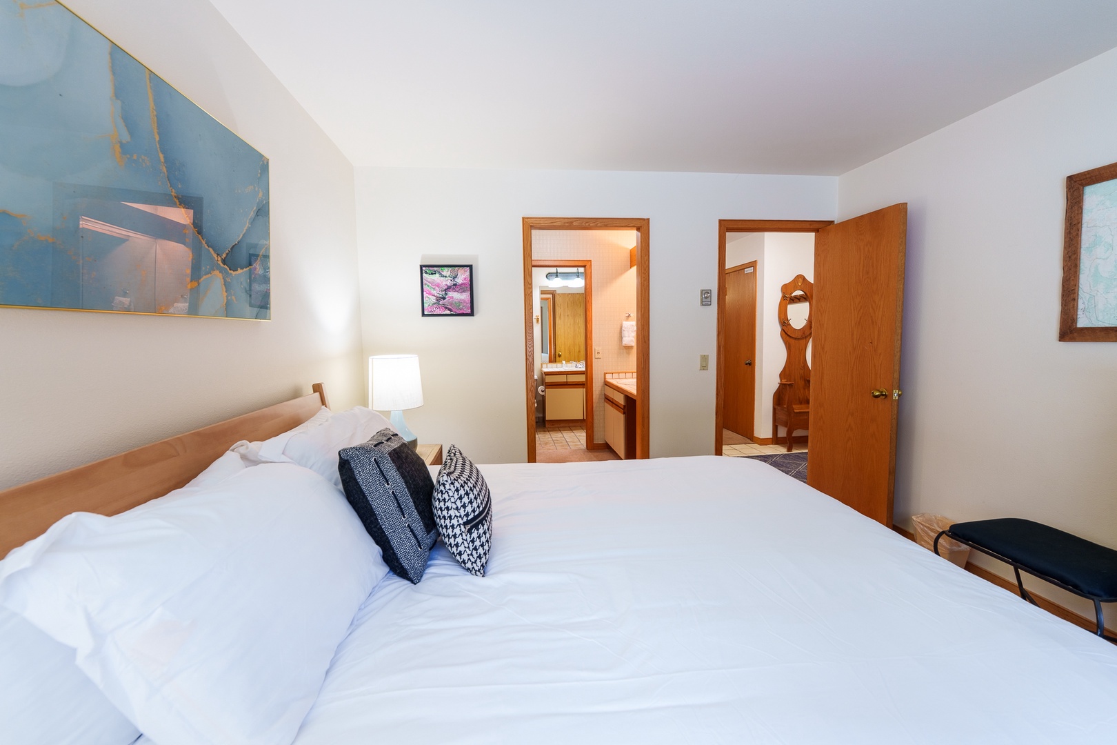 Sink into crisp white linens and let the soothing blue artwork calm your mind in this peaceful bedroom retreat.