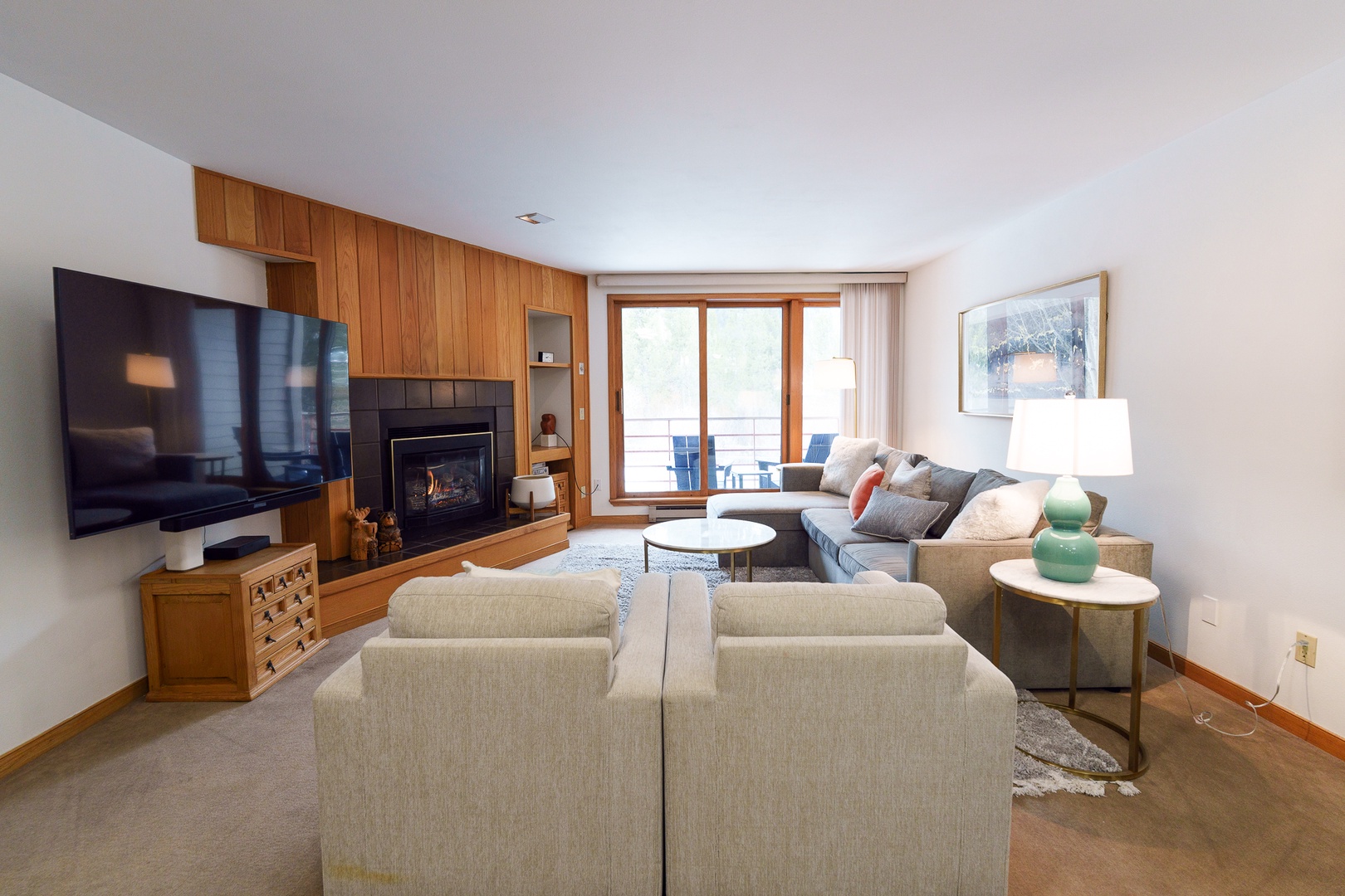 Unwind in your spacious living room with cozy fireplace, modern entertainment center, and comfortable seating for memorable evenings together.