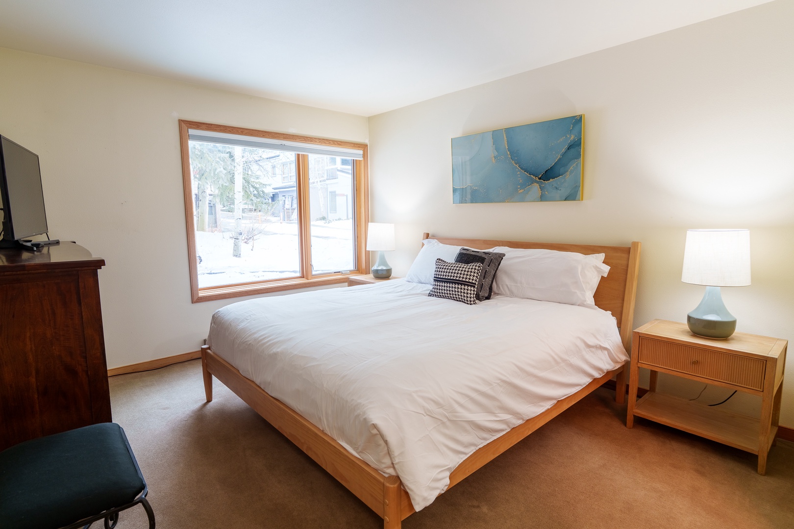 Your serene bedroom retreat features crisp linens, warm wood furnishings, and natural light streaming through large windows for peaceful mornings.