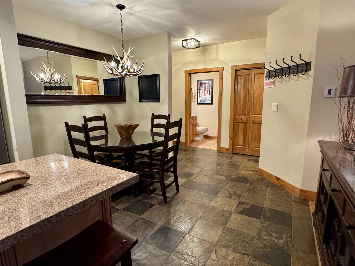 Cozy mountain retreat where rustic charm meets modern comfort. The dining area features an antler chandelier, slate floors, and warm wood tones—perfect for gathering and creating memories.