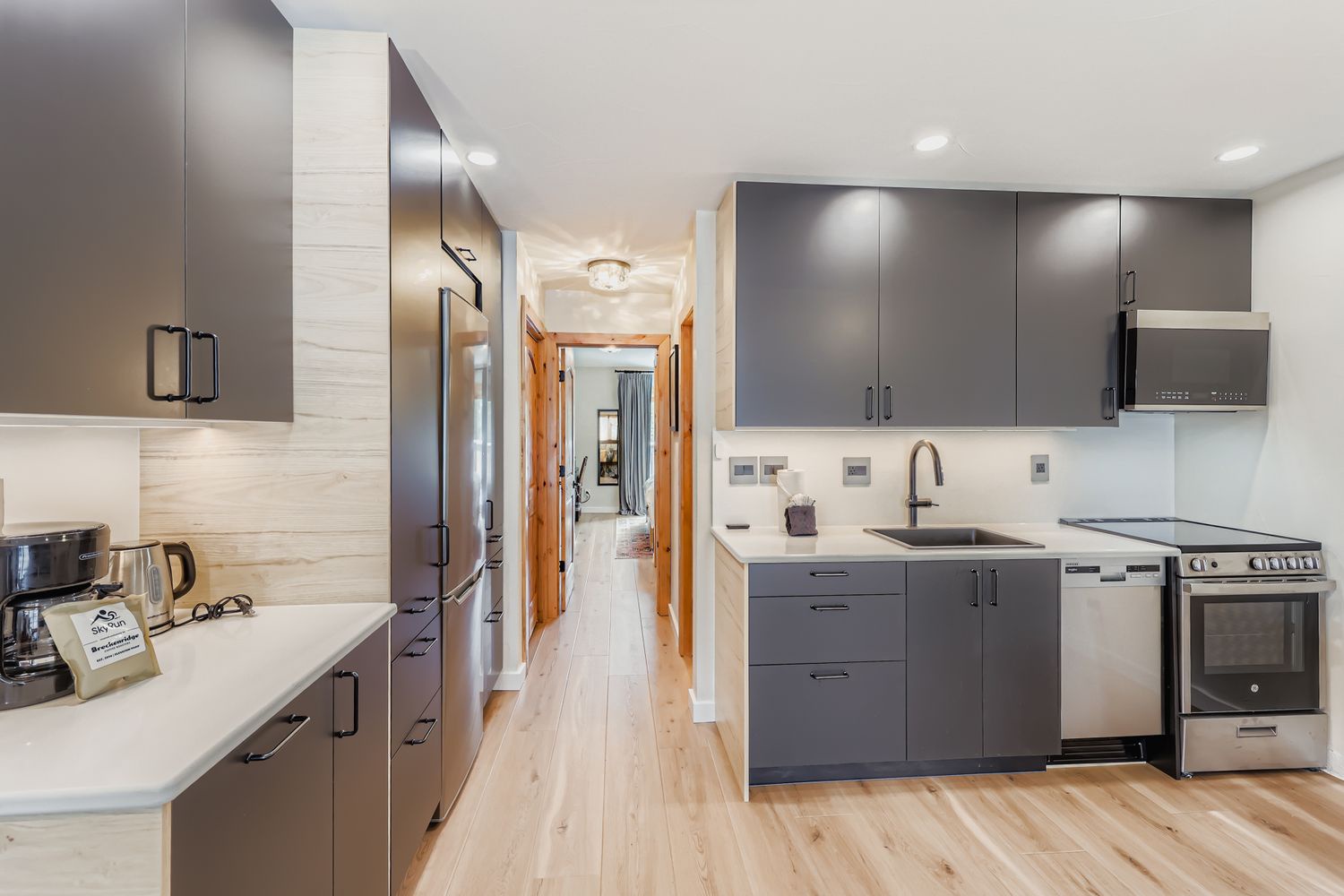 Your fully equipped modern kitchen features sleek grey cabinetry, stainless steel appliances, and ample counter space for all your culinary adventures during your stay.