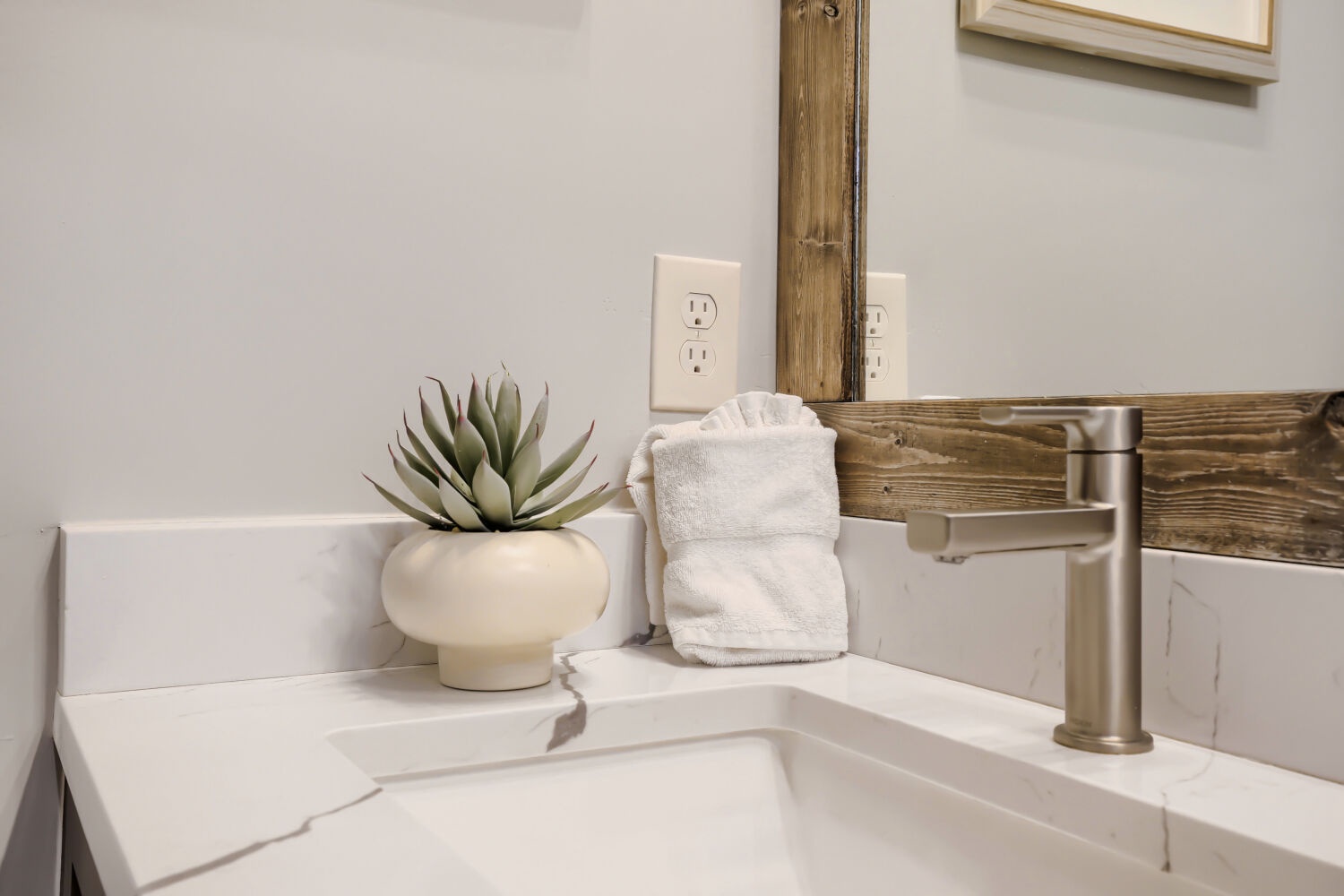 Freshen up in your modern bathroom with crisp white counters, brushed nickel fixtures, and thoughtful touches like fluffy towels ready for you.