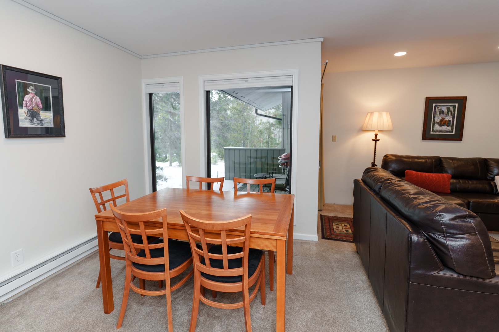 Your comfortable living and dining space features warm wood furnishings and a cozy leather sofa, perfect for family meals and relaxing together after your mountain adventures.