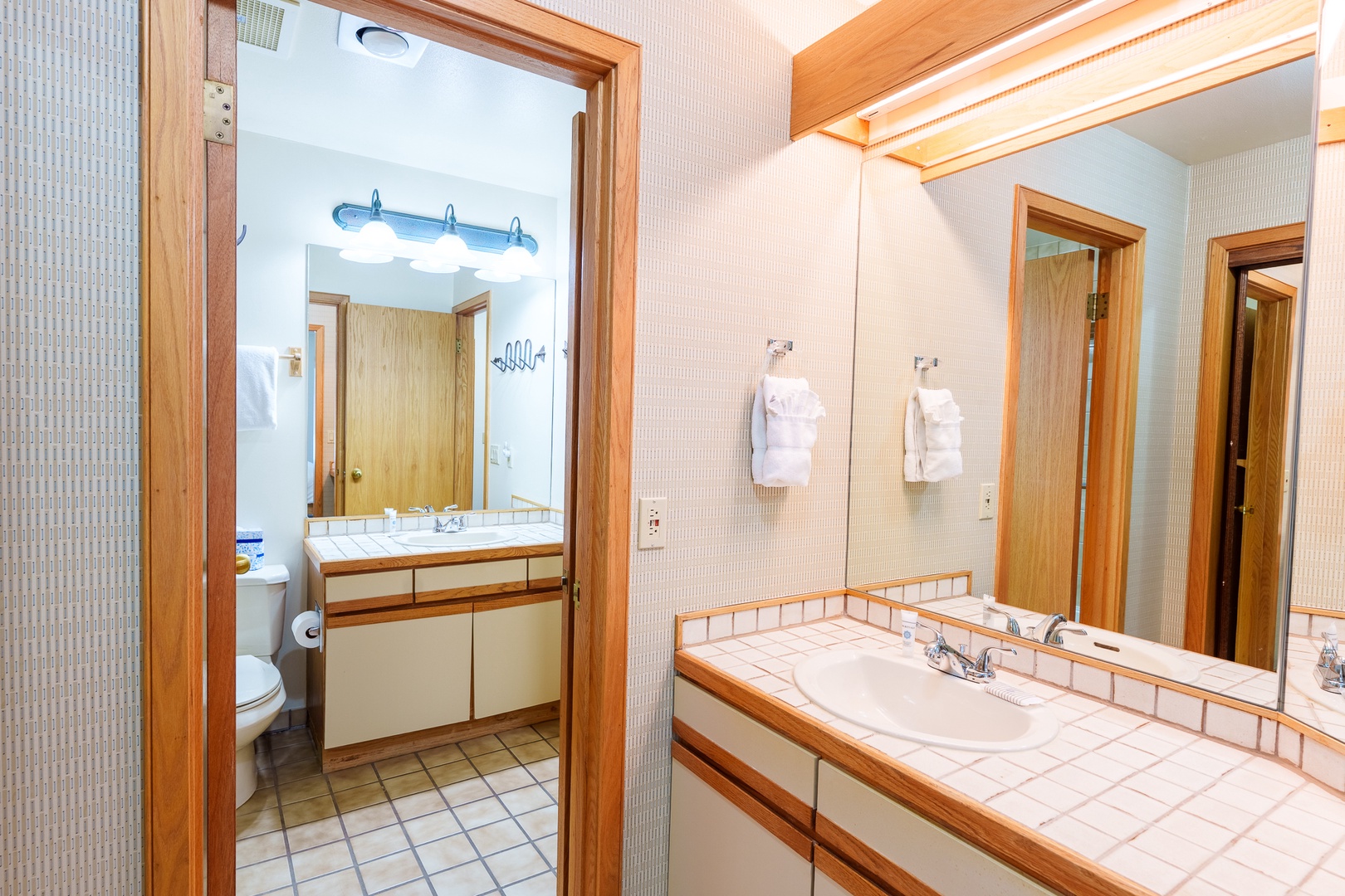 Freshen up in your spacious bathroom with double vanities, fluffy towels, and warm wood accents that create a cozy, home-like feel.