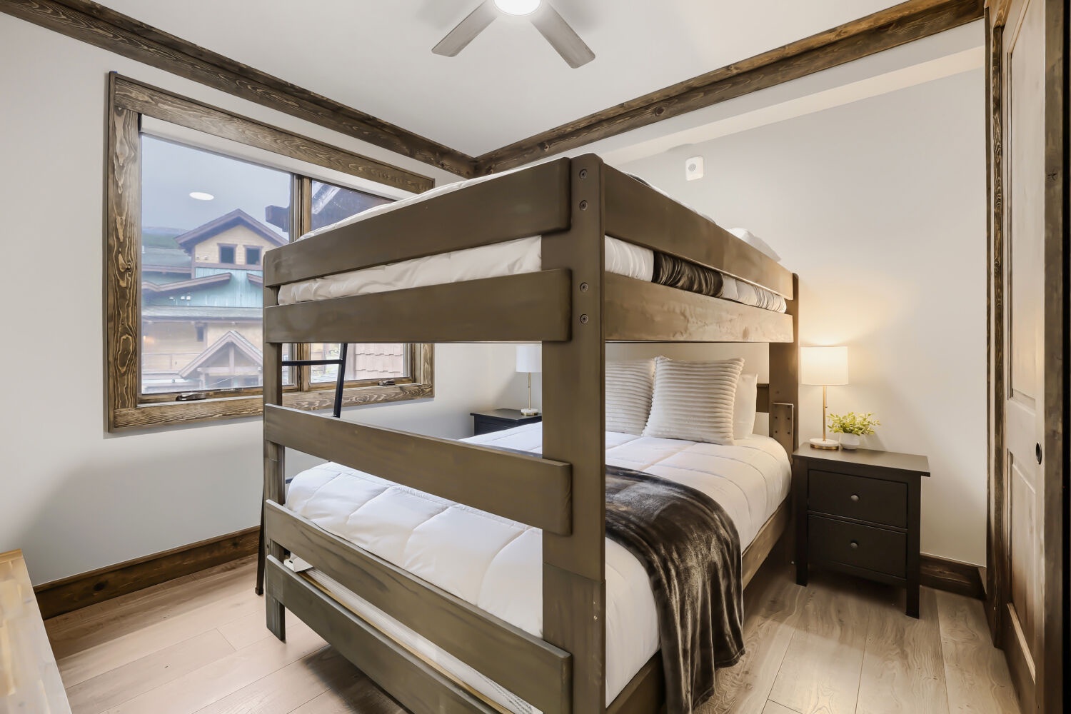 This cozy bedroom features sturdy bunk beds with plush linens, rustic wood beams overhead, and soft bedside lighting—perfect for your family or group to rest after a day of adventure.