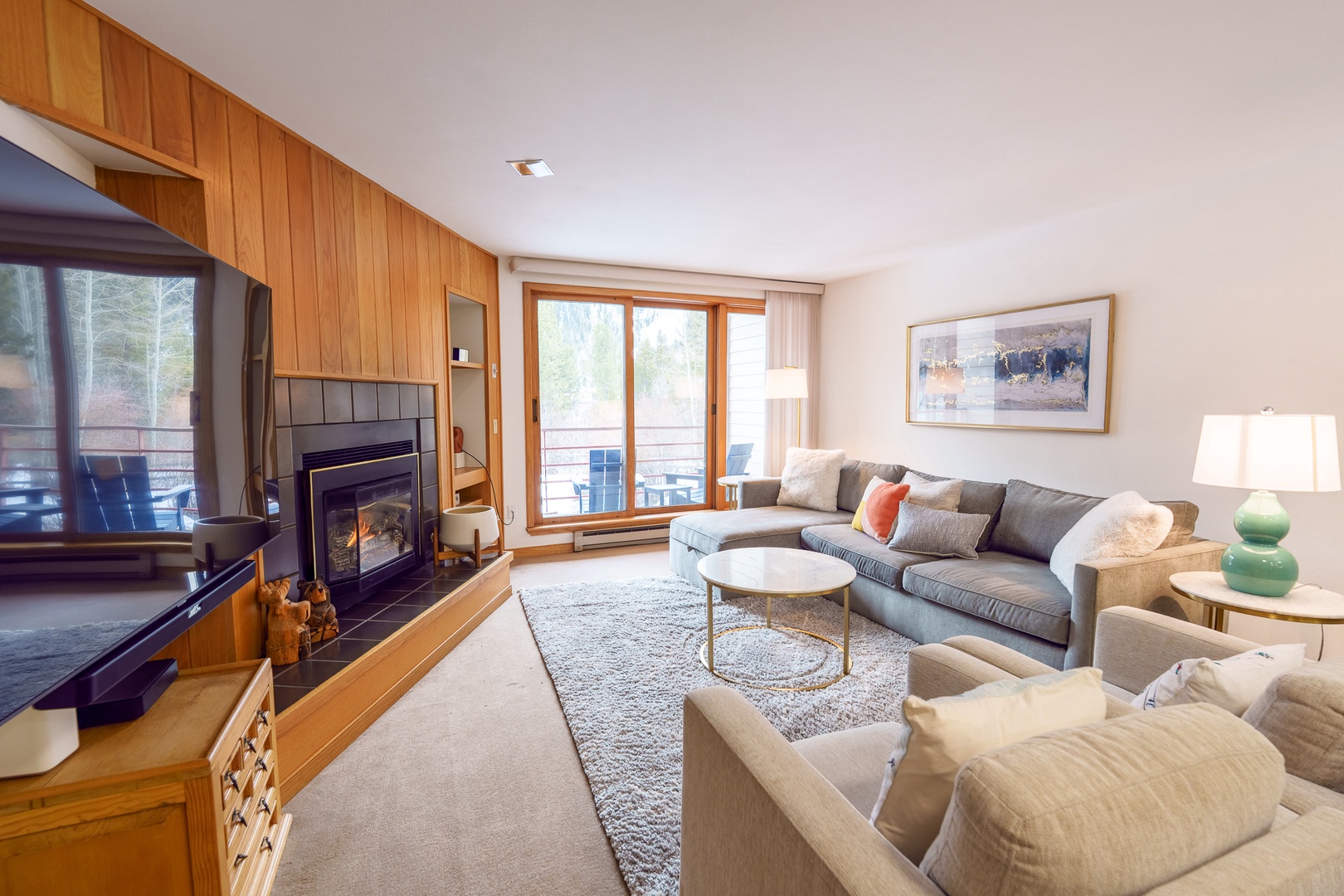 Unwind in your cozy living room with plush seating, crackling fireplace, and balcony views of nature's beauty.