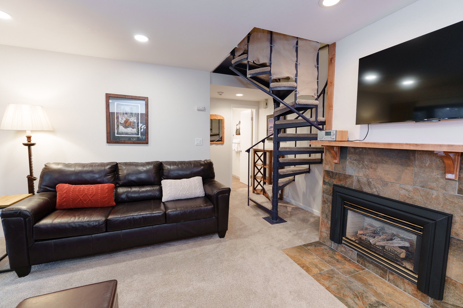 Relax in your cozy living area with plush leather seating, warm fireplace, and entertainment center - perfect for unwinding after your mountain adventures.