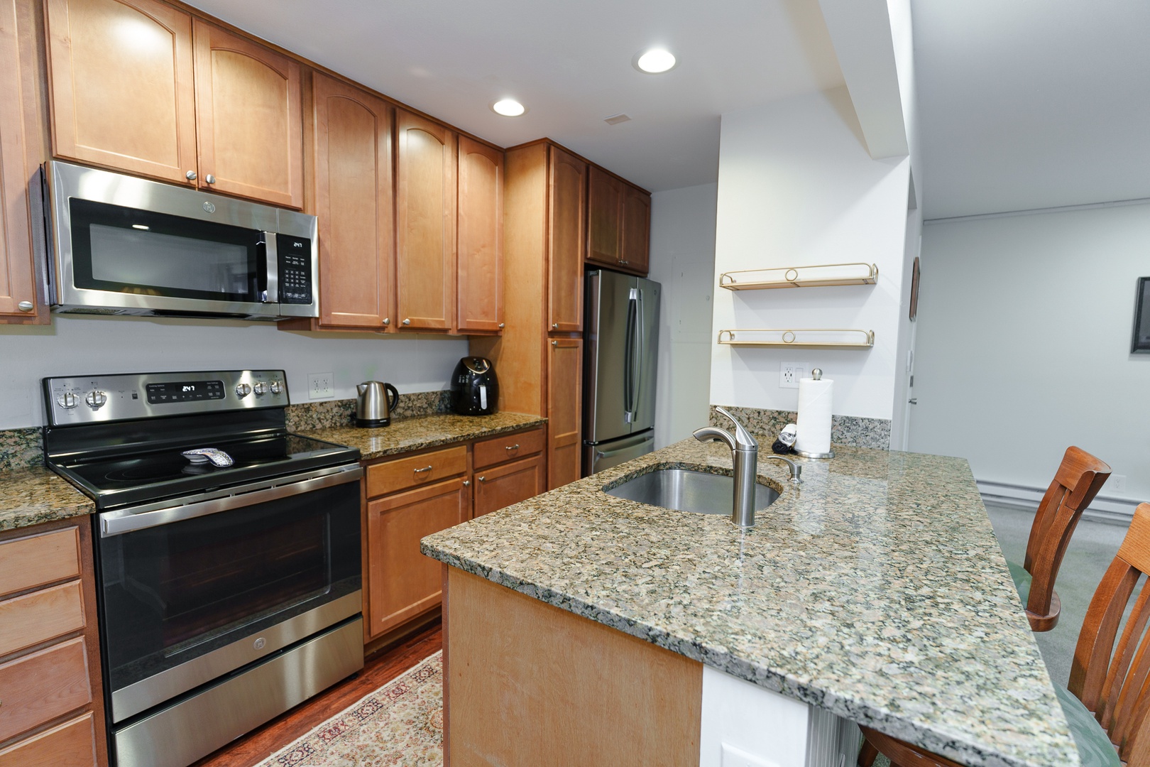 Your fully equipped kitchen features granite countertops, stainless steel appliances, and a breakfast bar where you can enjoy meals and prep with ease.