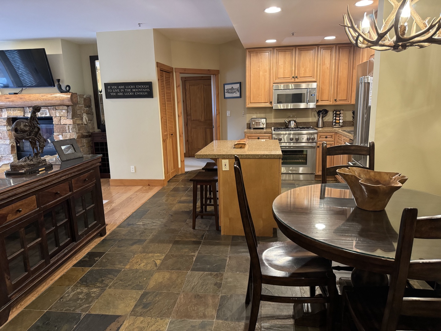 Gather around the granite island in your fully equipped kitchen, then relax by the stone fireplace in the open living space—perfect for preparing meals and enjoying cozy mountain evenings together.