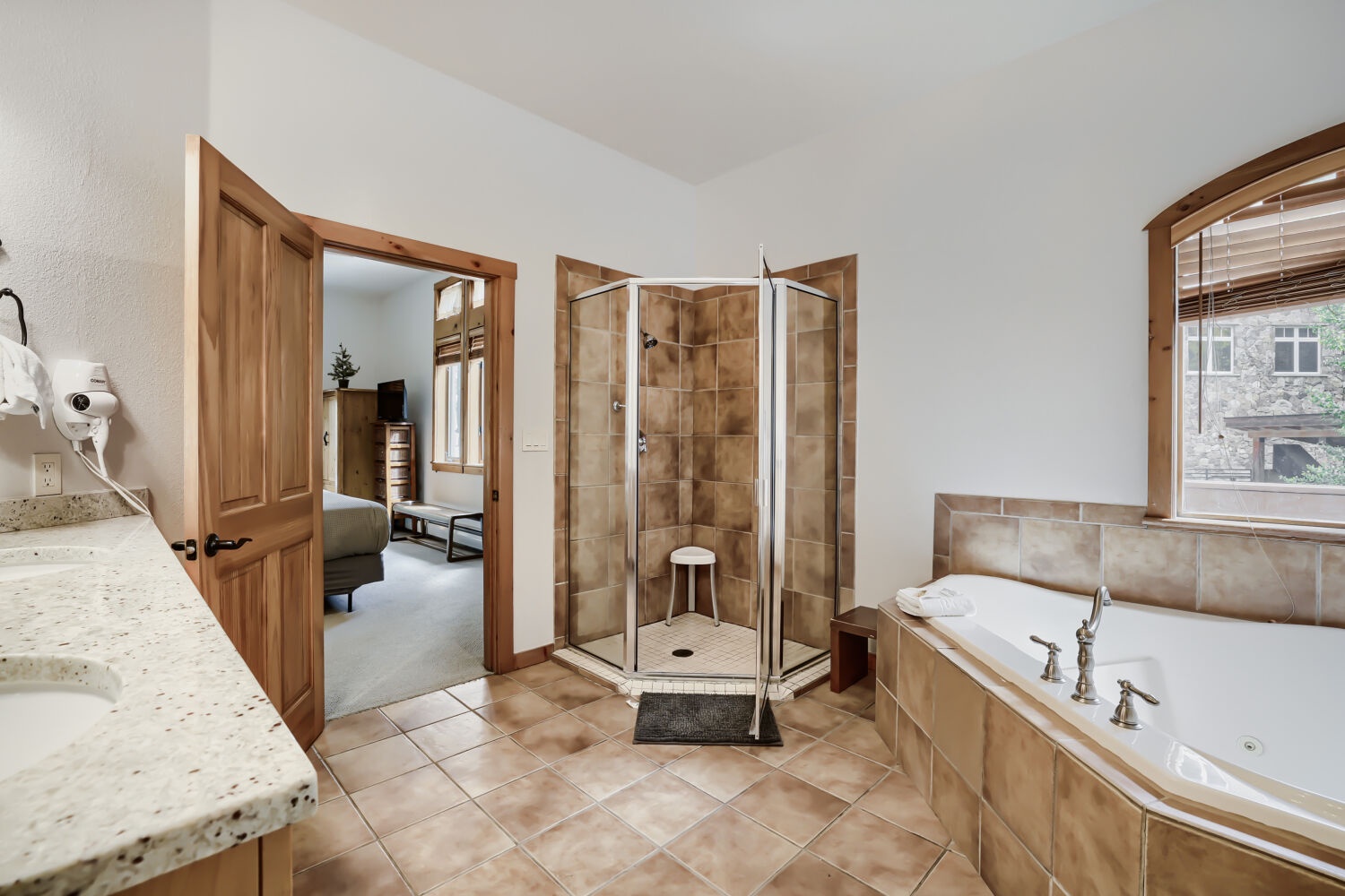 Unwind in your private spa-inspired bathroom, complete with a spacious corner tub, walk-in shower, and warm natural light that invites relaxation after every mountain adventure.