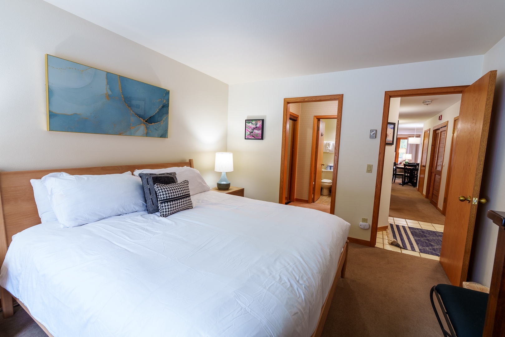 Sink into crisp white linens and let the soft bedside lighting ease you into relaxation in this thoughtfully appointed bedroom.