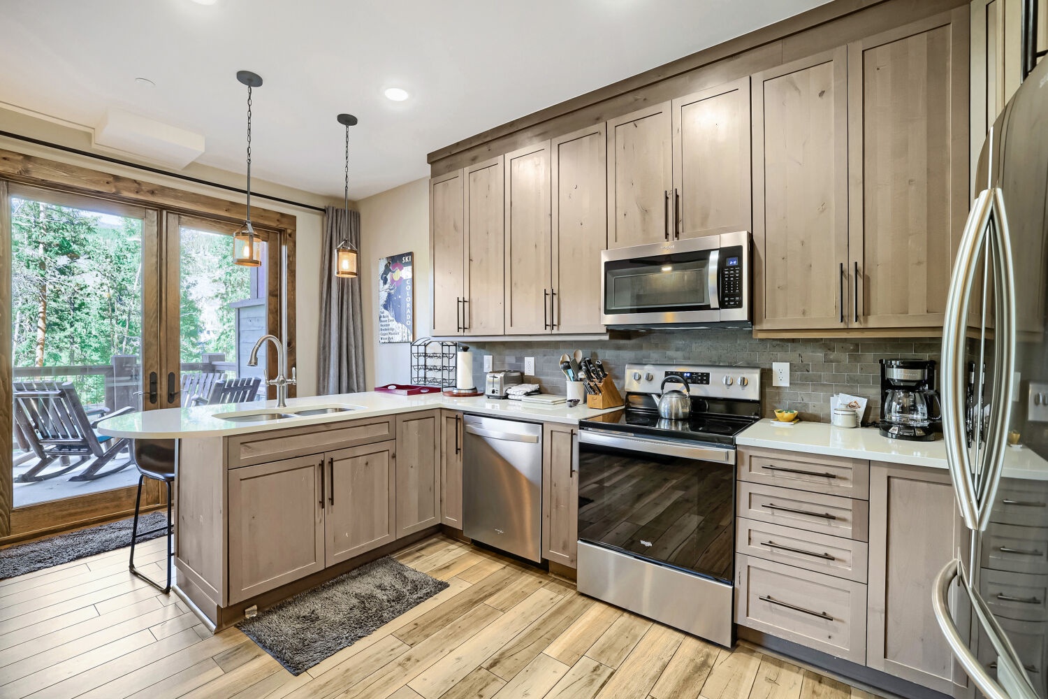 Cook your favorite meals in this fully equipped kitchen with stainless steel appliances, sleek countertops, and warm wood cabinetry. Glass doors open to your private outdoor space.