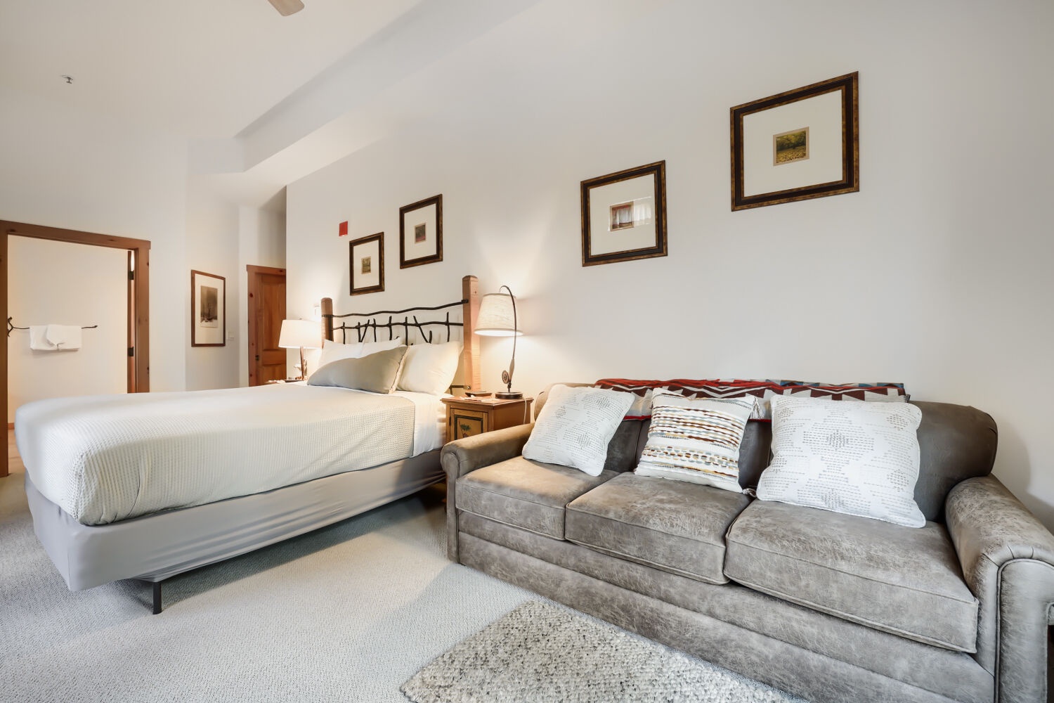 Unwind in your spacious suite with a plush king bed and comfortable sofa, bathed in soft natural light. Your private retreat offers vaulted ceilings and thoughtful details to make you feel at home.