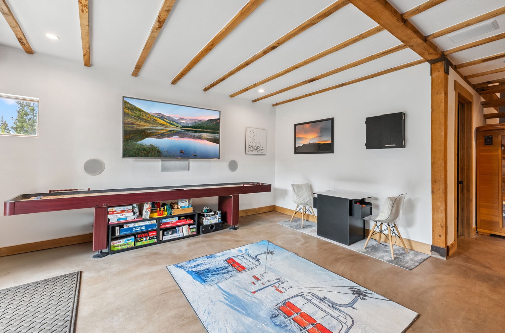 Your personal game room awaits with soaring wood-beam ceilings, a shuffleboard table for friendly competition, and cozy seating beneath mountain vistas on the big screen.