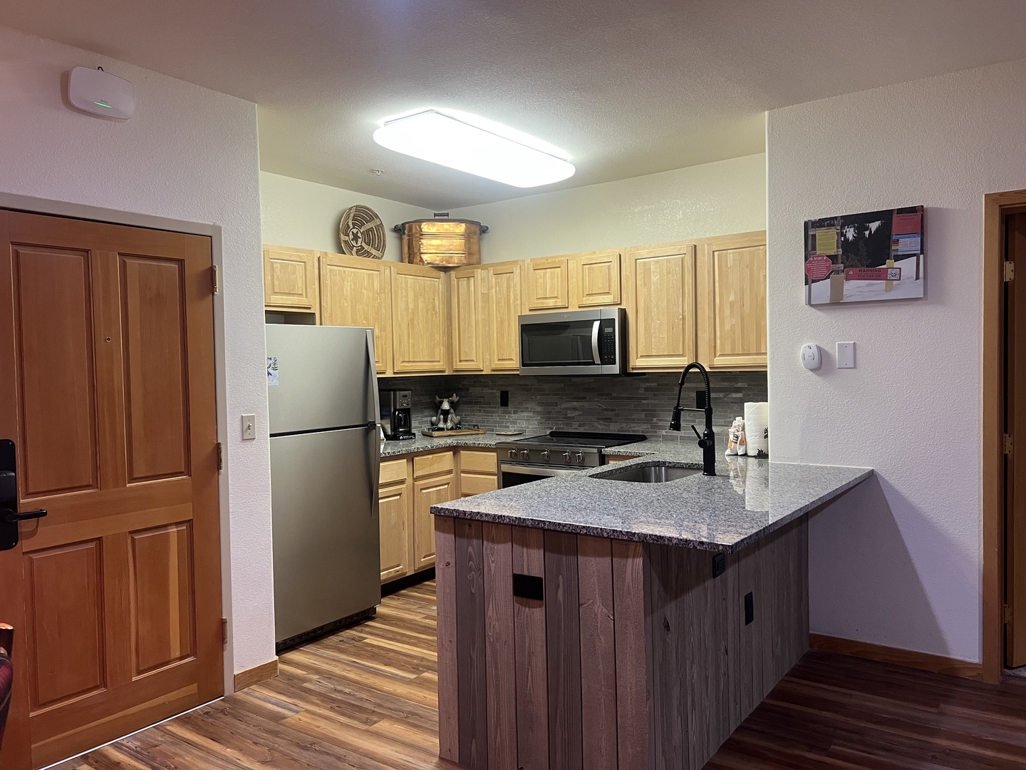 Your fully equipped kitchen awaits with granite countertops, stainless appliances, and a spacious island—perfect for preparing home-cooked meals and gathering with loved ones during your mountain getaway.
