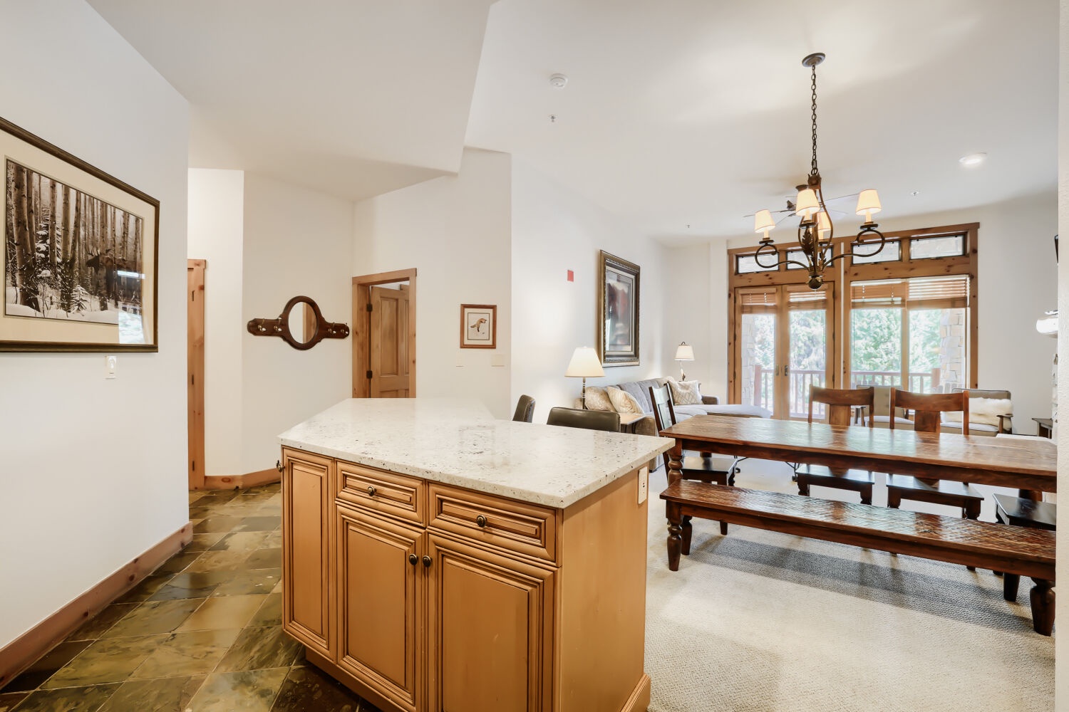 Open-concept retreat with soaring ceilings, spacious living and dining areas, granite island, and large windows framing peaceful views.