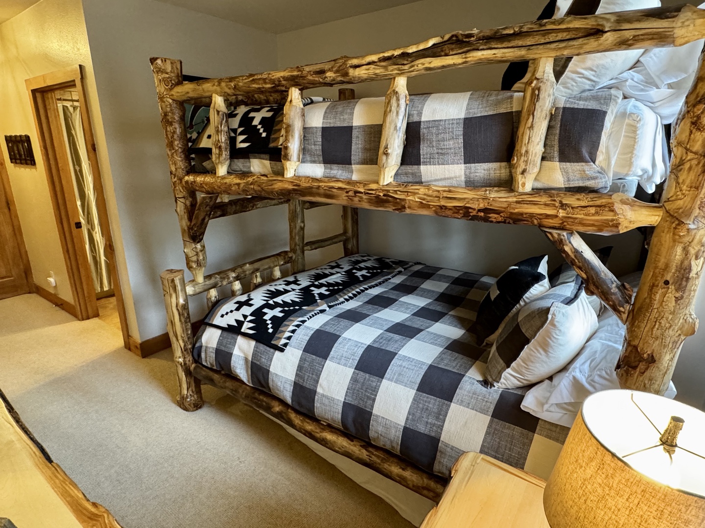 Your cozy bunk room features handcrafted rustic log beds with plush buffalo check bedding, perfect for the kids or extra guests after a full day of adventure.