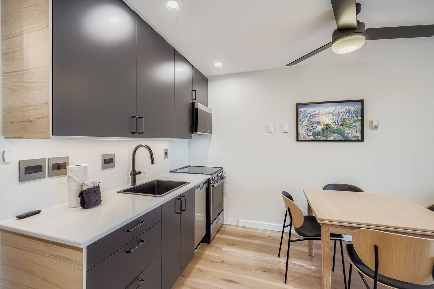 Your modern kitchen features sleek grey cabinetry, white countertops, and stainless steel appliances, creating the perfect space for preparing meals during your stay.