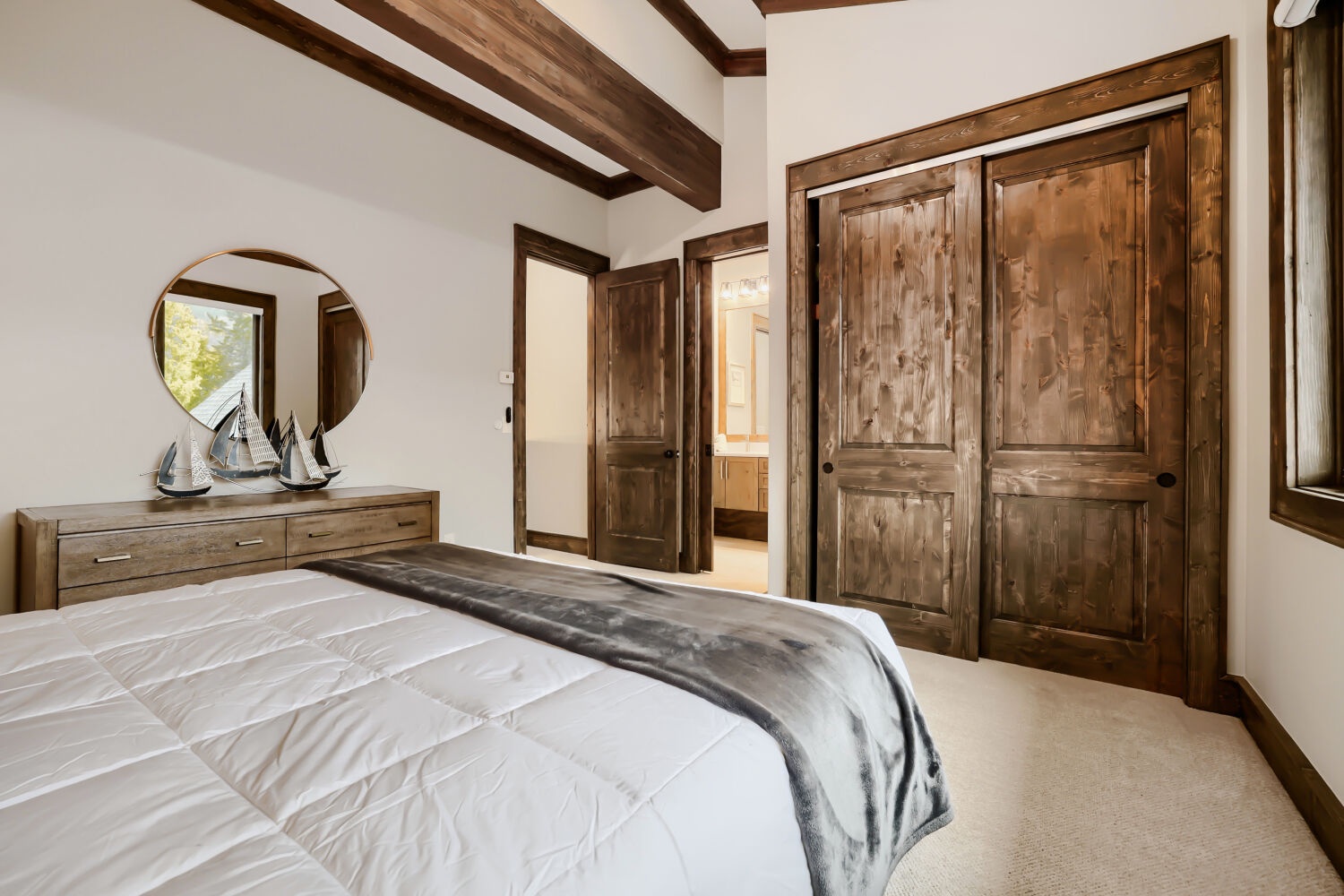 Rustic elegance meets mountain comfort in your bedroom with exposed wood beams overhead and handsome reclaimed wood doors. The crisp bedding and cozy throw invite you to sink in after a day of adventure.