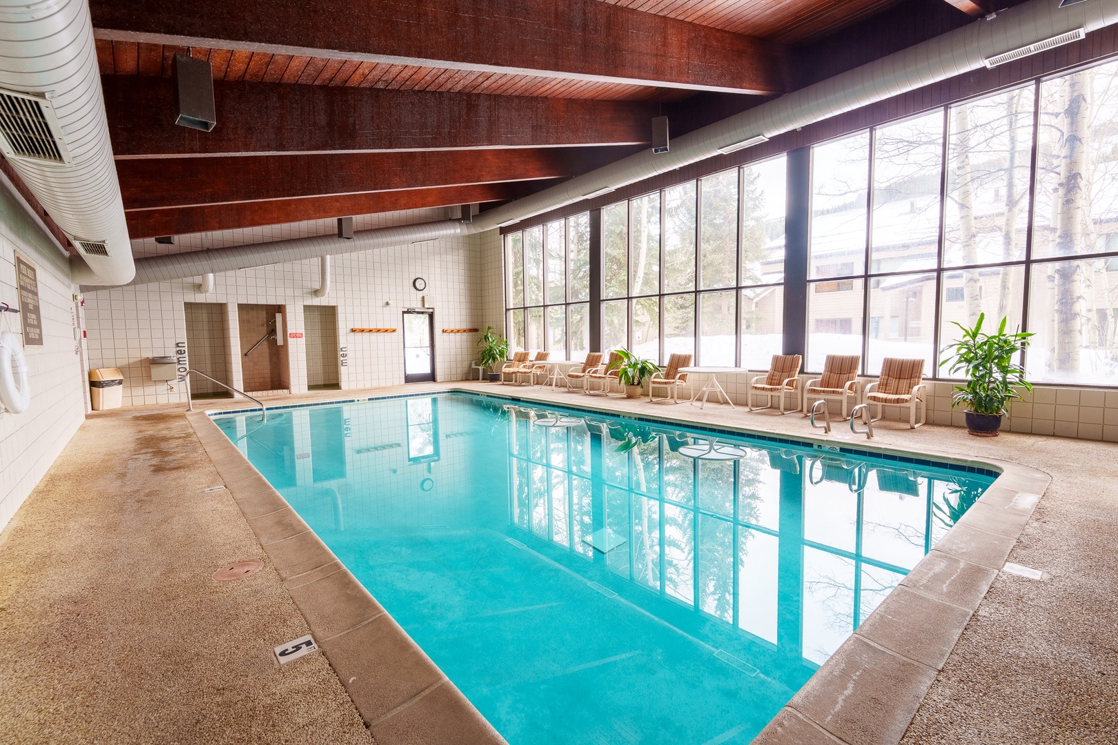 Your private indoor pool oasis awaits with crystal-clear waters, comfortable poolside seating, and natural light streaming through expansive windows.
